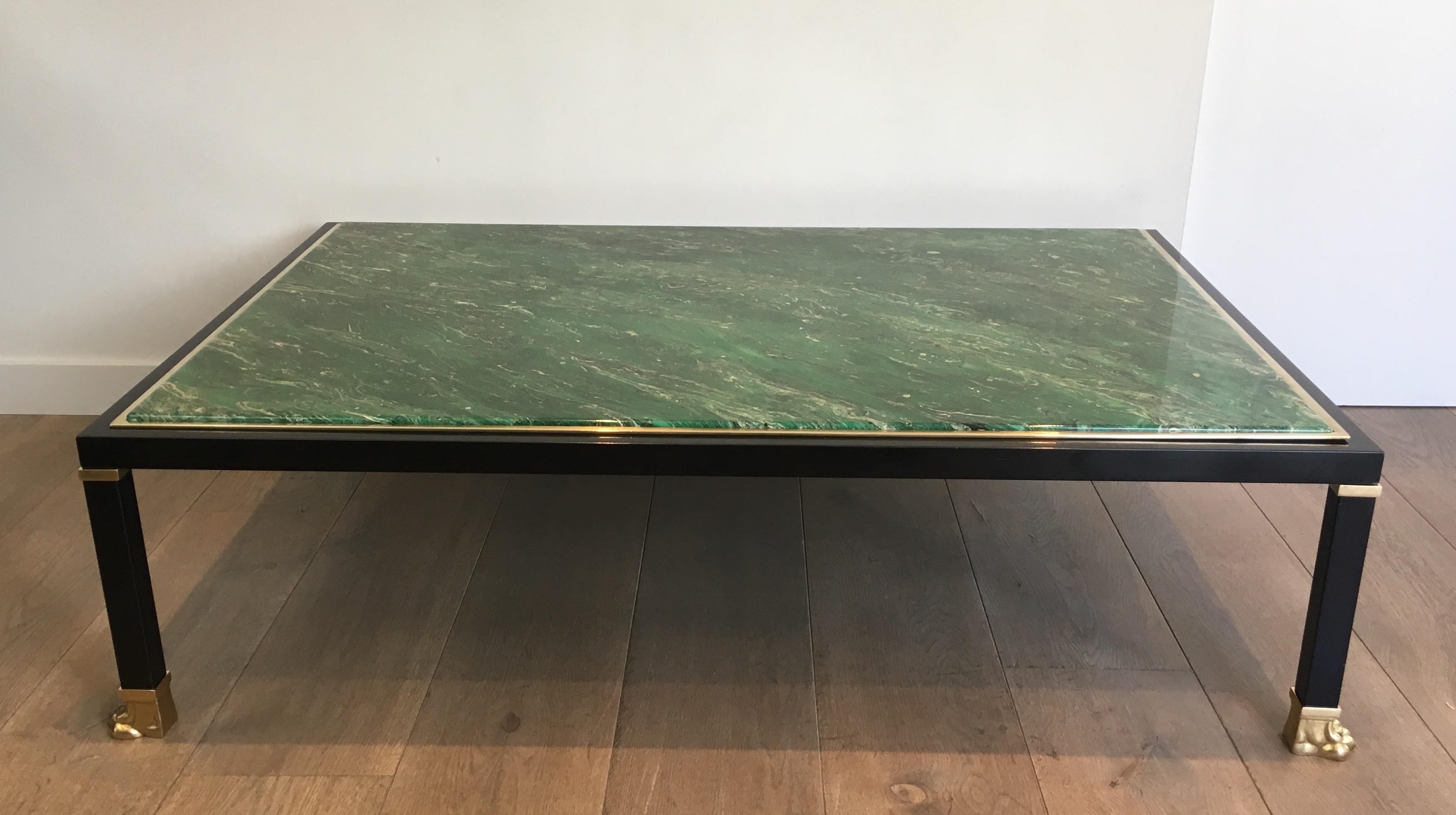 This exceptional coffee table is made of black lacquered metal, brass claw feet and a resin malachite style top. This unique piece is a special order by famous French designer Guy Lefèvre for Maison Jansen, circa 1970.