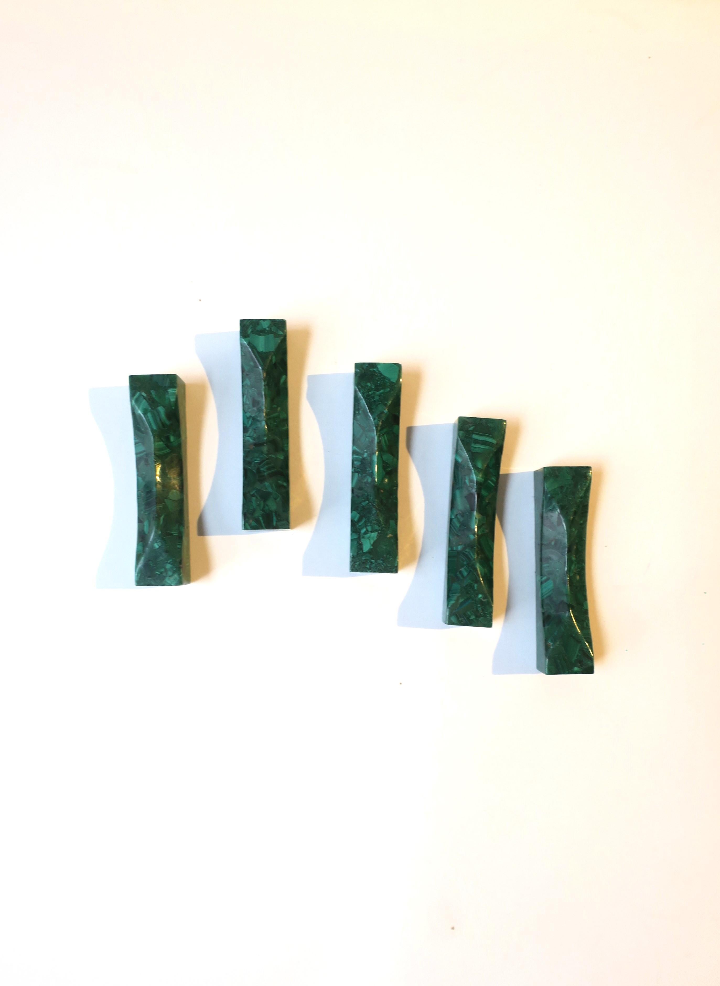 A beautiful and chic set of five (5) natural green malachite utensil rests, circa mid-20th century. Shown in images supporting a knife and soup spoon. A rare set. A great hostess gift. A special set for the ultimate entertaining environment.