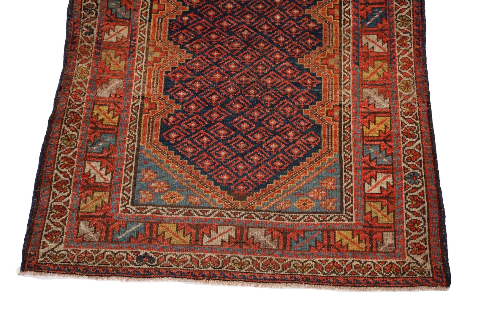 Ein Malayer-Teppich ist ein wahres Meisterwerk, das mit äußerster Sorgfalt und Liebe zum Detail gewebt wurde. Dieser besondere Malayer-Teppich hat ein tiefes marineblaues Feld, das mit atemberaubenden tiefroten geometrischen Motiven verziert ist.
