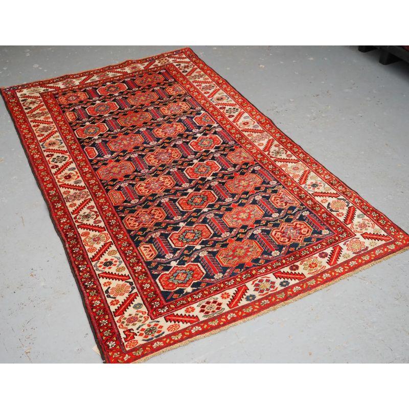 A good example of a Malayer rug with an interesting shield design on an indigo blue ground

The shield design is often found on Afshar tribal rugs, on this rug it is very well drawn and balanced. The ivory ground floral border frames the rug