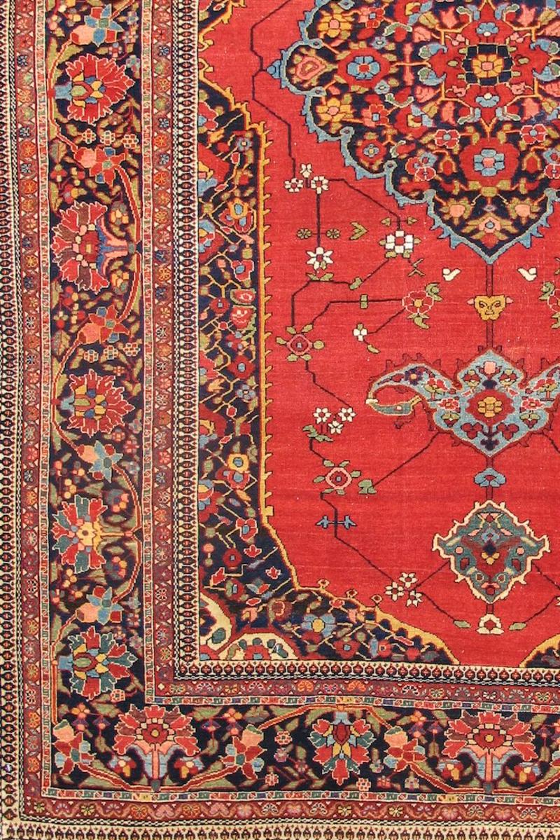 This exceptionally pleasing Persian rug melds elegance with happiness using the classic arrangement of a central medallion within a cartouche-shaped field. Against a rose ground a network of white blossoms traces the floral medallion, palmette
