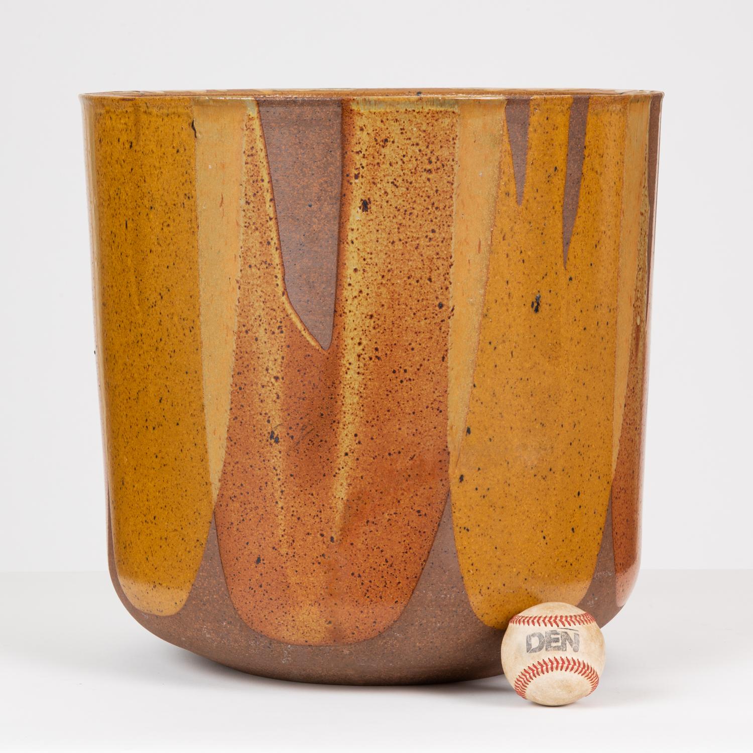 Malcolm Leland’s tulip-shaped LT-24 planter for Architectural Pottery with David Cressey's Pro/Artisan “Flame Glaze.” This planter has a rounded bottom that widens towards the opening, a simple shape rendered dramatic by the variegated glaze