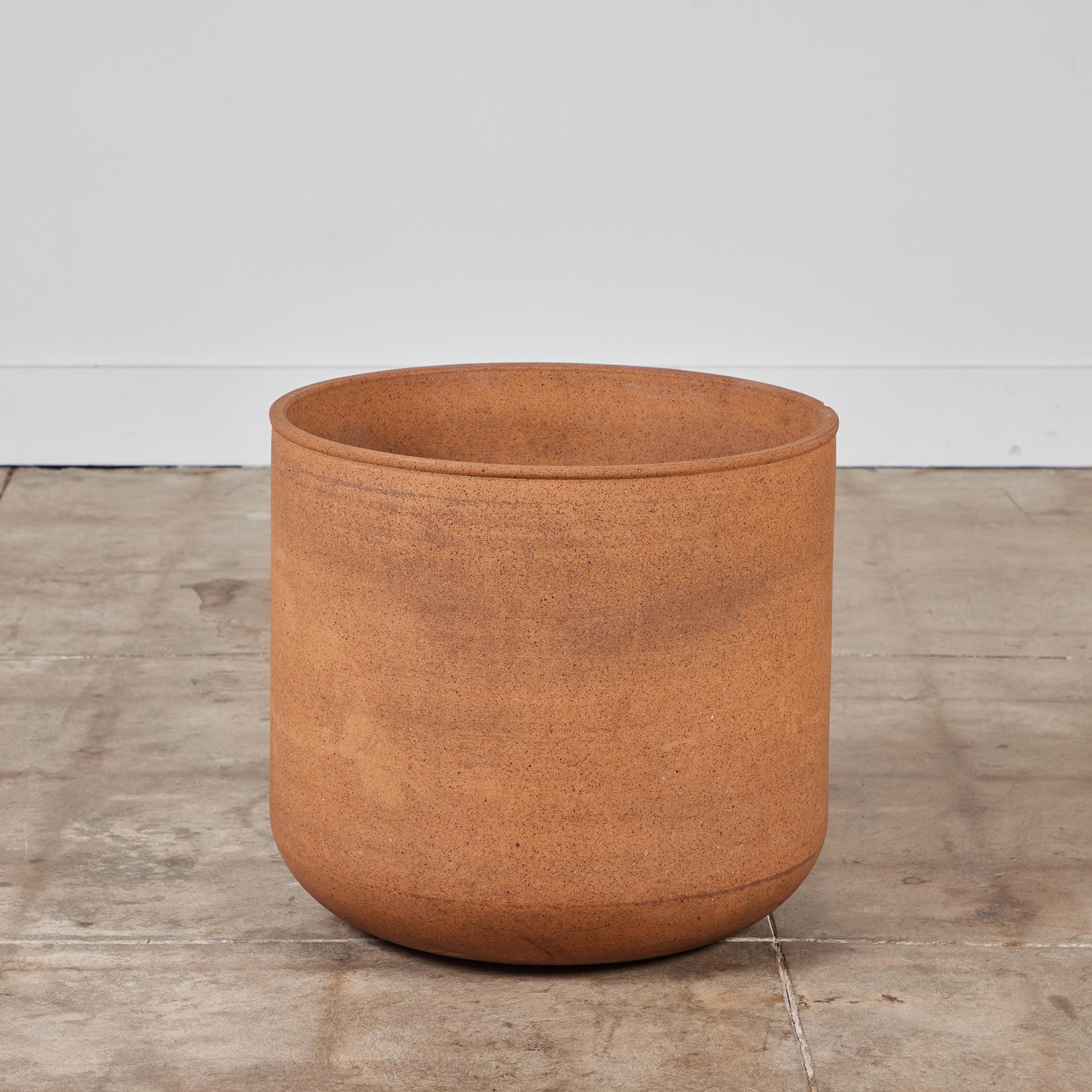 A tulip-shaped stoneware planter by Malcolm Leland for Architectural Pottery. This planter has a rounded bottom that widens towards the opening, a simple shape with a natural unglazed stoneware body.

Dimensions
21