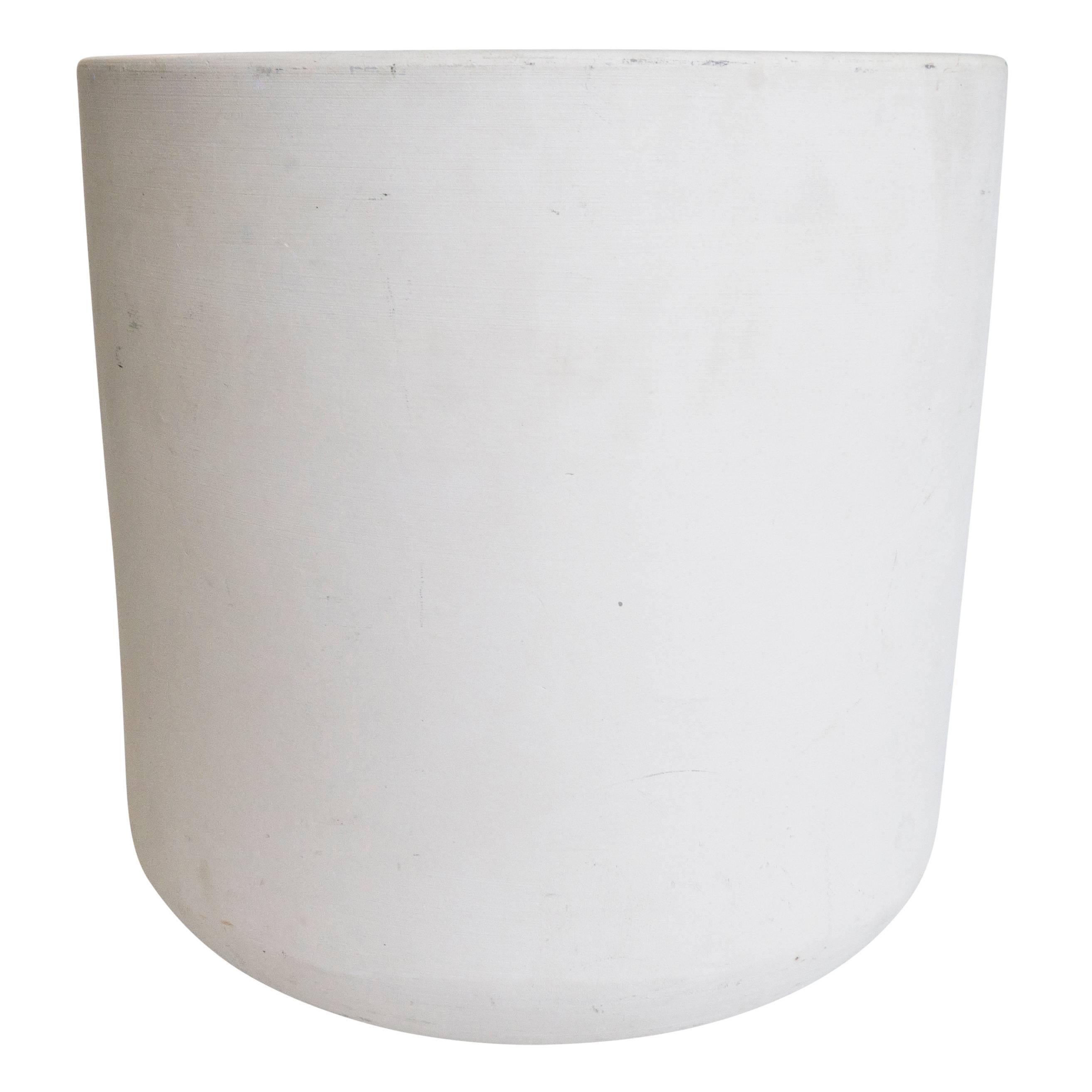 Classic white cylinder made for Architectural Pottery by artist Malcolm Leland. This strong yet petite vessel has the remnants of the Architectural Pottery logo at the bottom. Modern garden art for the home that can blend well outdoors or in a