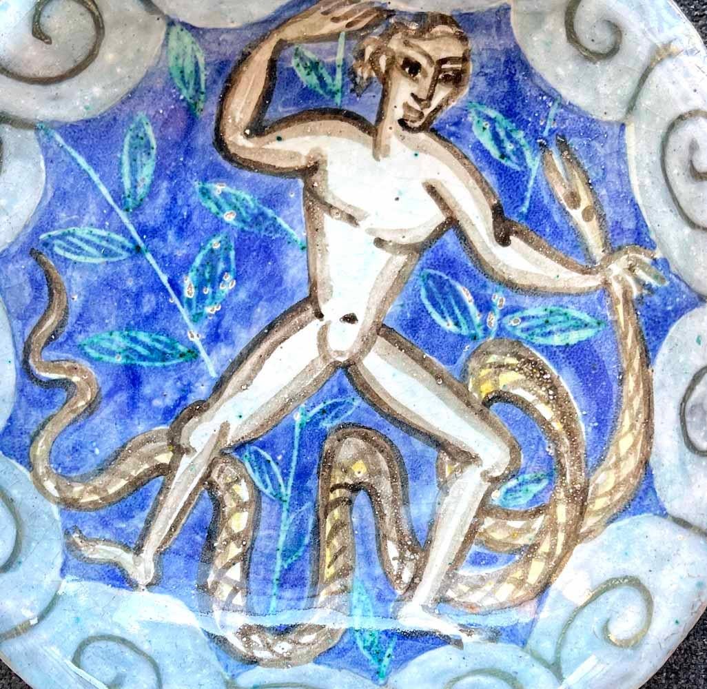 Shaped and painted in gorgeous blue and gray glazes by Edouard Cazaux, master sculptor and ceramicist who exemplified the French Art Deco style at its finest, this ceramic dish or bowl features a nude male figure in combat with a large serpent.