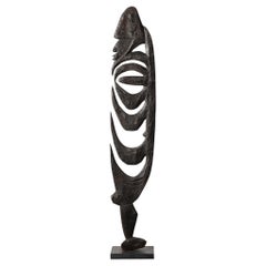 Escultura masculina de madera tallada Yipwon sobre base de piedra