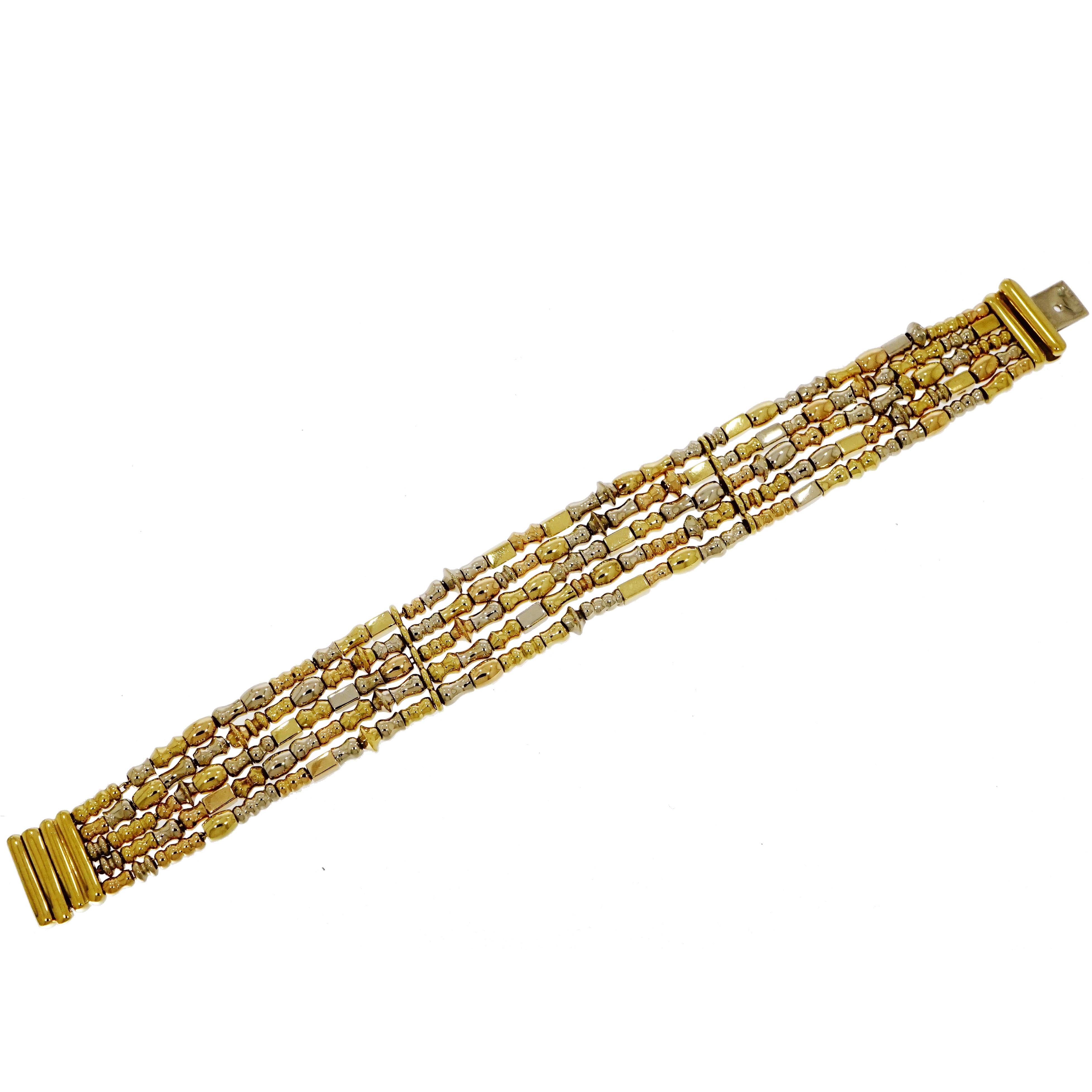 Un ensemble de 5 rangs de barres et de perles solides de tailles et de formes variées ajoutant un style exquis à ce précieux bracelet. 
Fabriqué en Italie par Manfredi en or blanc et jaune 18 carats.
Mesure 7 pouces de long et environ 17 mm de