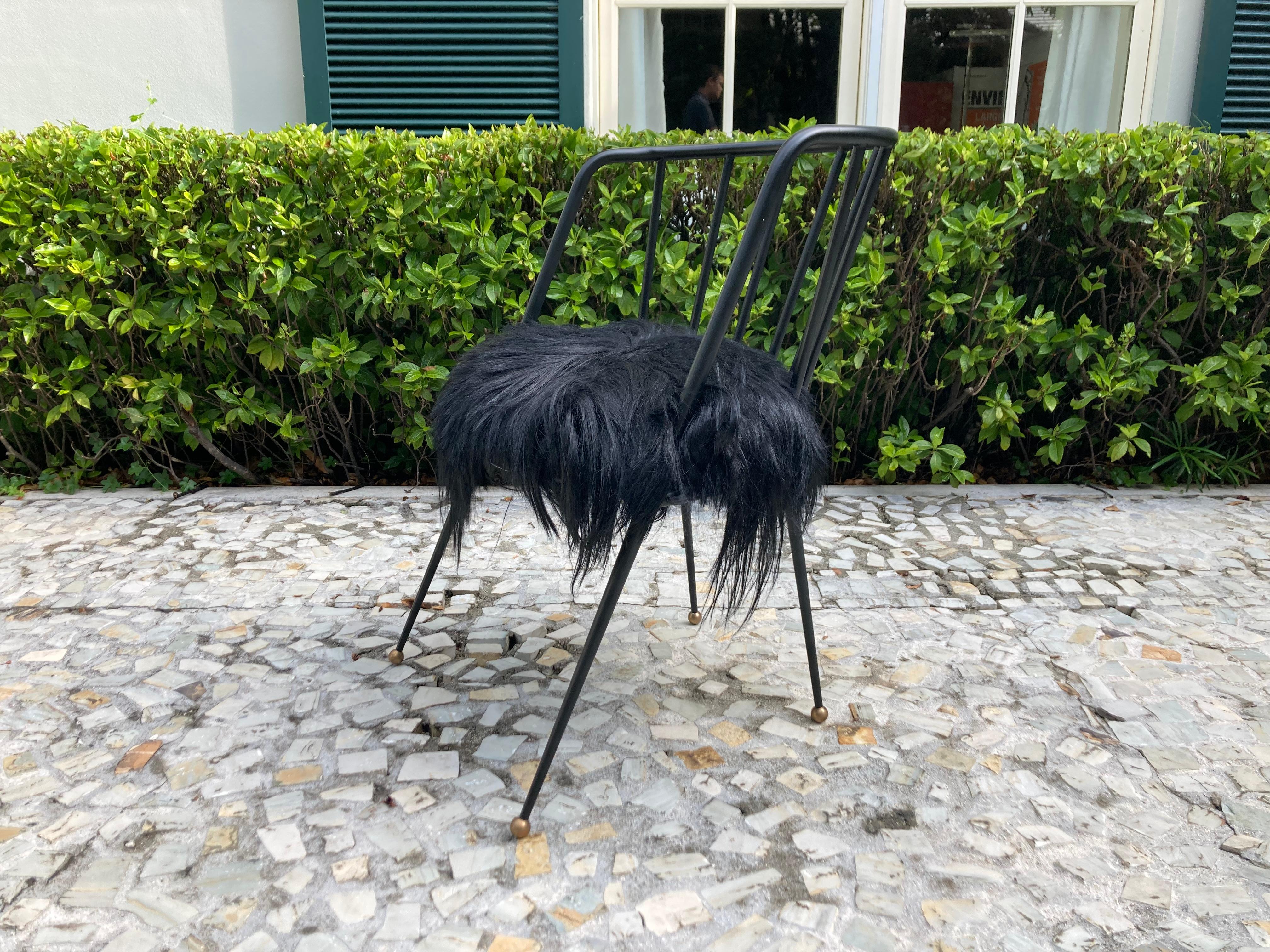 Malibu chair by Kelly Wearstler, hollow steel and finished with gunmetal coating. The tapered legs are tipped with antique brass ball feet. Seat is Black Goat fur.