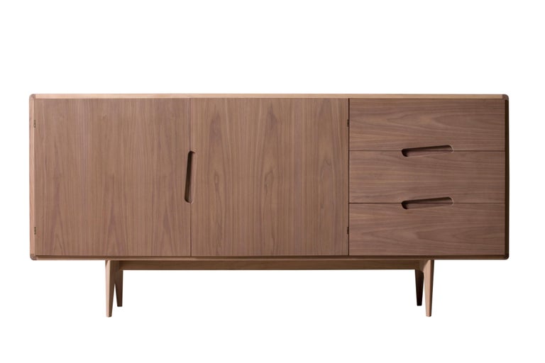 Mid century style sideboard made of ash wood with 2 doors and 3 drawers, characterized by diagonally carved handles. Base legs with triangular section.
Made in Italy by Morelato
   