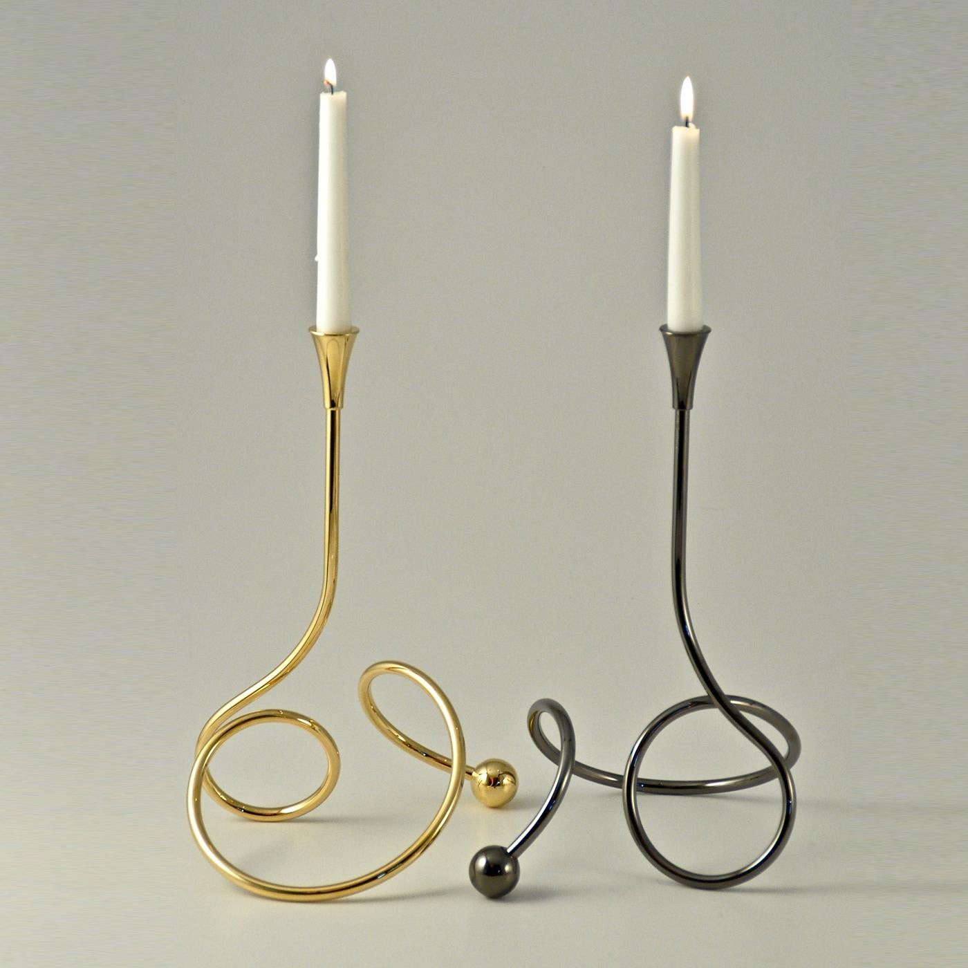 Superb individual handmade candleholders with an enveloping base of curved metal. The perfect arrangement is a playful composition of three intertwined pieces, plated with pure silver, yellow gold, and titanium respectively.