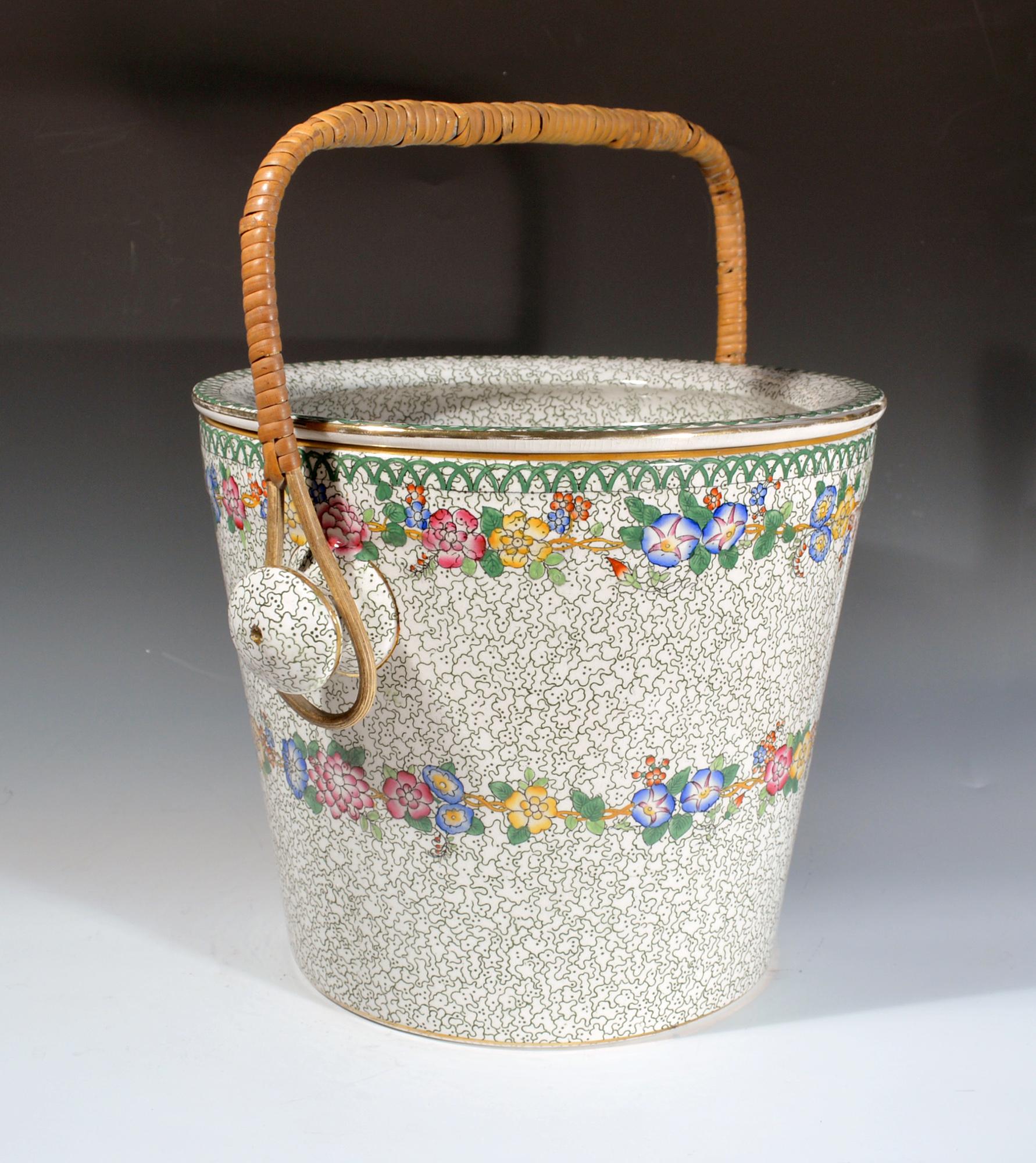 Secchio e coperchio in ceramica di Maling,
Articoli Cetem,
1908-1930.

Il secchio cilindrico alto e il coperchio con manico rimovibile in vimini sono ricoperti da un disegno verde a forma di girella e da un'ampia fascia floreale intorno al
