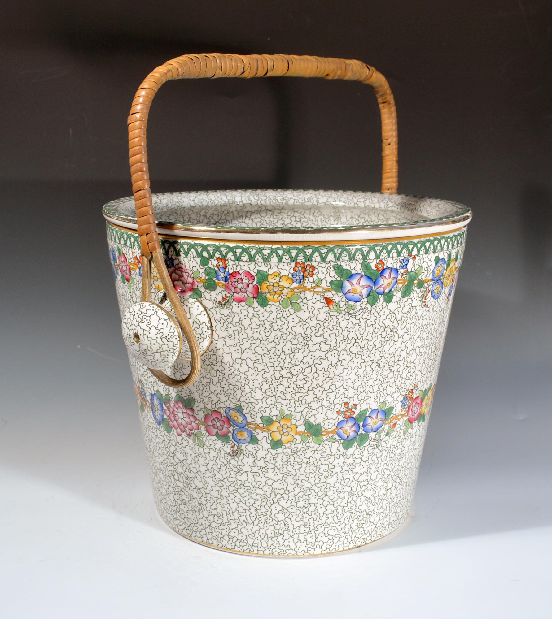 Maling pottery pail and cover,
Cetem ware,
1908-1930.

The tall cylindrical pail and cover with removable wicker handle is covered with a green swizzle design and with a wide floral band around the centre and rim. The recessed cover has a