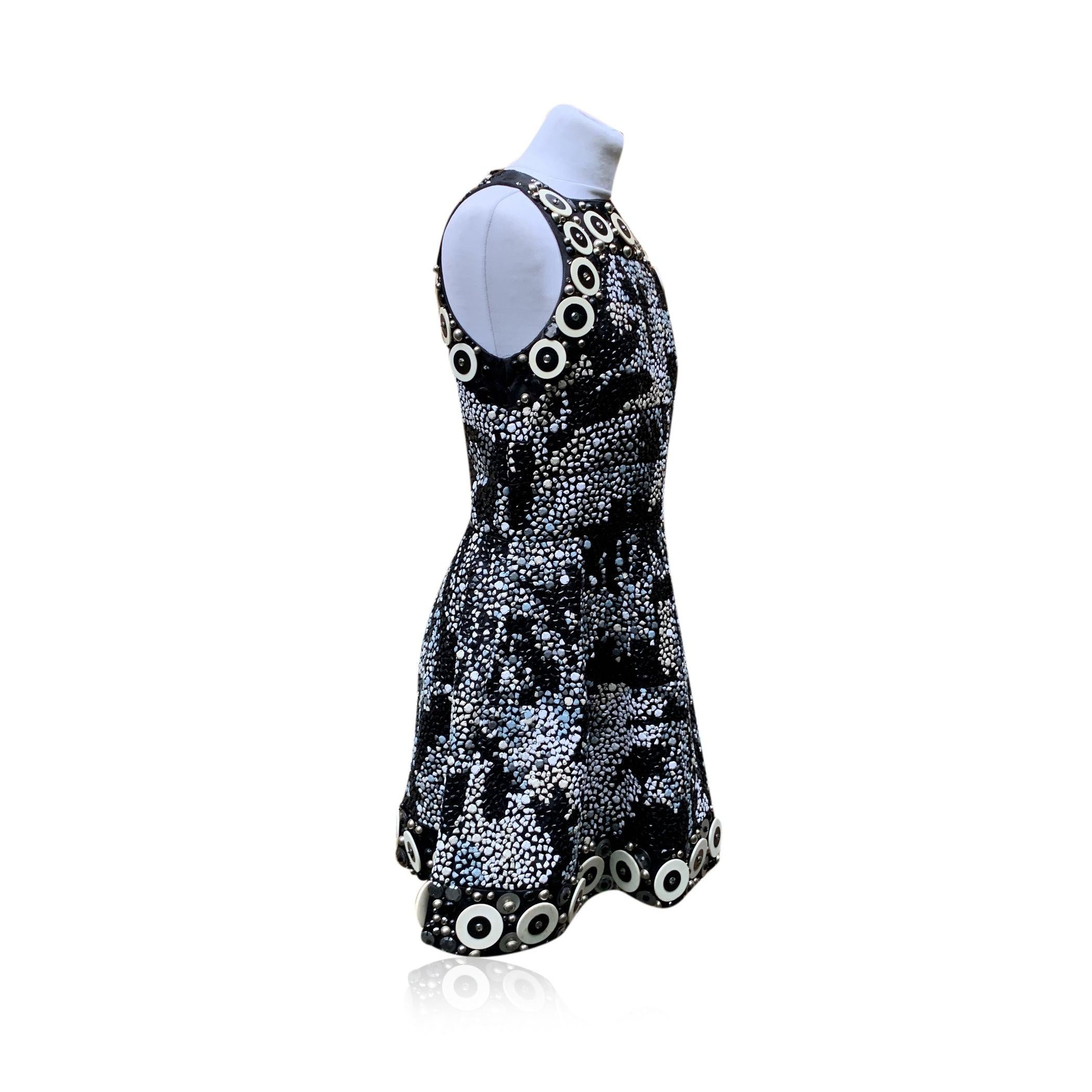 Precioso vestido corto sin mangas de Malo totalmente bordado con cuentas blancas y negras y piedras de resina. Estilo sin mangas. Cierre trasero con cremallera. Composición:58% nailon, 42% seda. Forro 100% seda. Talla: 44 IT (La talla mostrada para