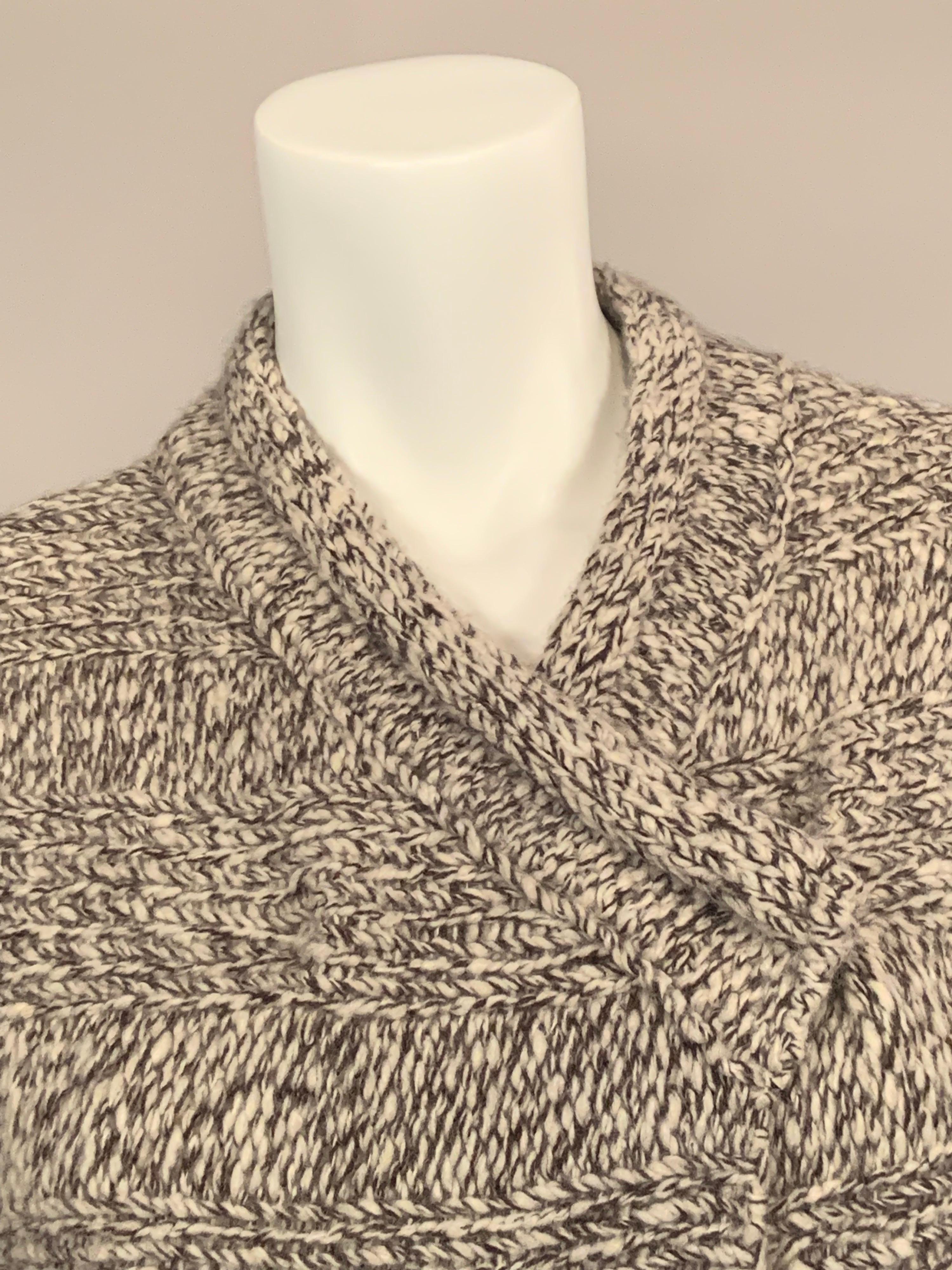 This super soft, light weight cashmere sweater or jacket from Malo, Italy is knit with a heavy gauge, two tone cashmere yarn for extra coziness and warmth, not to mention extra style.  The piece has a roll collar above a three snap closure. 
There