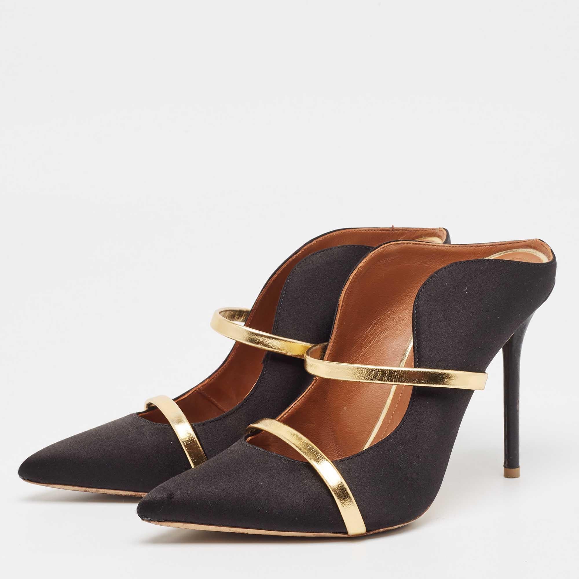 Admired for its waved silhouette this pair of Malone Souliers mules will make sure the spotlight follows you everywhere. The strap detailing across its black exterior enhances its contemporary shape. Created from satin and leather the pair features