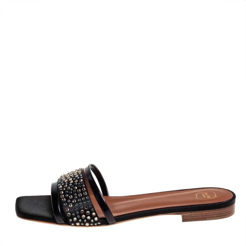 Brimming with unparalleled sophistication, these gorgeous black sandals from Malone Souliers are ready to help you fashion a statement look. Crafted from satin and leather and flaunting an open-toe silhouette, these sandals exhibit dazzling crystal