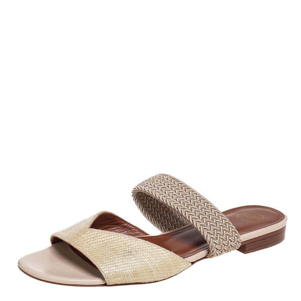 These striking Rodena slides are from Malone Souliers. They have been crafted from fabric in an open-toe silhouette. They flaunt a woven raffia strap across the vamps and sturdy soles. The comfortable leather-lined insoles leave no stone unturned