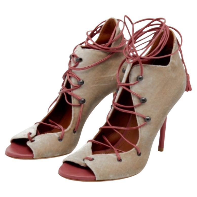 Setzen Sie Akzente mit diesen Sandalen von Malone Souliers! Von ihrer Form und ihren Details bis hin zu ihrer allgemeinen Attraktivität strahlen sie einen anspruchsvollen Stil aus. Die Sandalen sind aus grauem Samt und rosa Leder gefertigt und