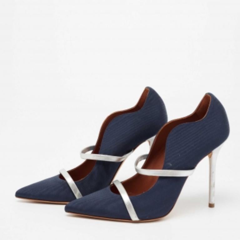 Ces emblématiques escarpins Maureen sont non seulement gracieux et chics, mais aussi très confortables. Confectionnées en toile bleu marine, les brides en cuir argenté soulignent la forme de vos pieds. Des talons fins complètent ces chaussures.