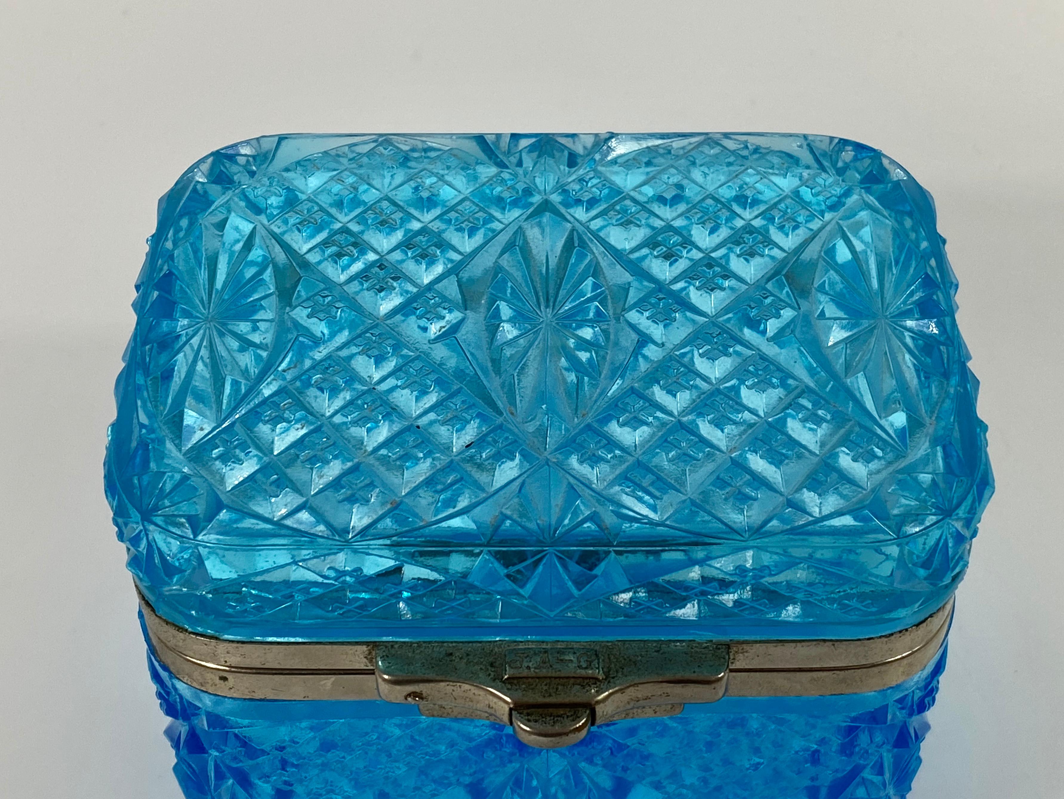 £390.00
Maltsev Glassworks casket, Russia, c. 1910. The aquamarine blue colored casket decorated with diamond point surrounding panels of stylized flower heads.
Having a plated metal mount, with the inscription ‘J.A-G’ to the clasp.
Medium: