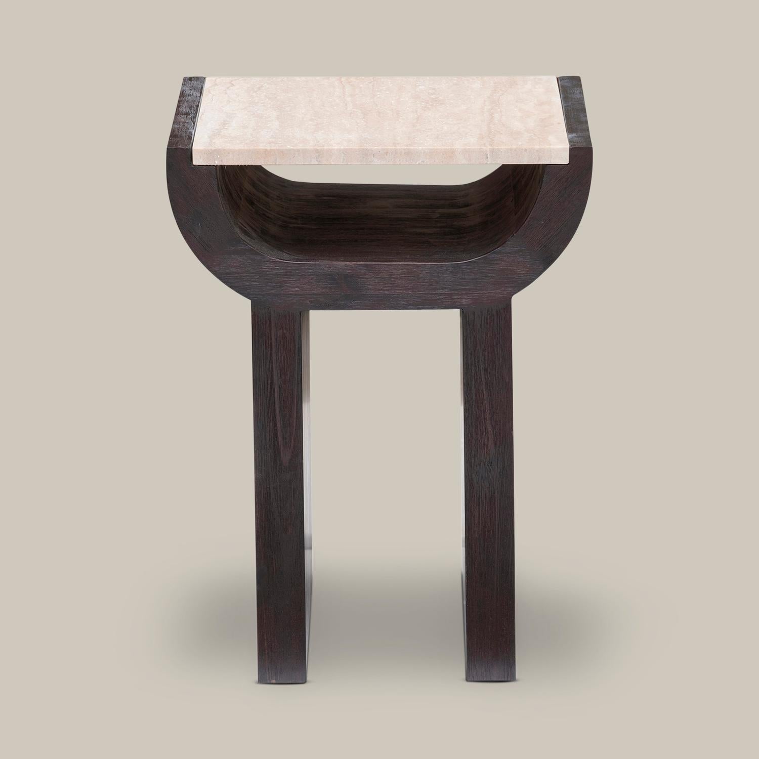 The Malus side table features dual walls that rise to an inverted arch beneath a honed natural travertine top in this artistic, sculptural side table. The inverted arch doubles as storage space for books, magazines and journals. This piece floats