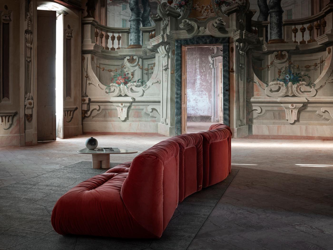 Volumi generosi delineati da curve sinuose e un rivestimento in velluto arancione stropicciato definiscono questo maestoso divano modulare, concepito per celebrare la fluidità e la sensualità del mambo. Delicati e lineari dettagli trapuntati sono