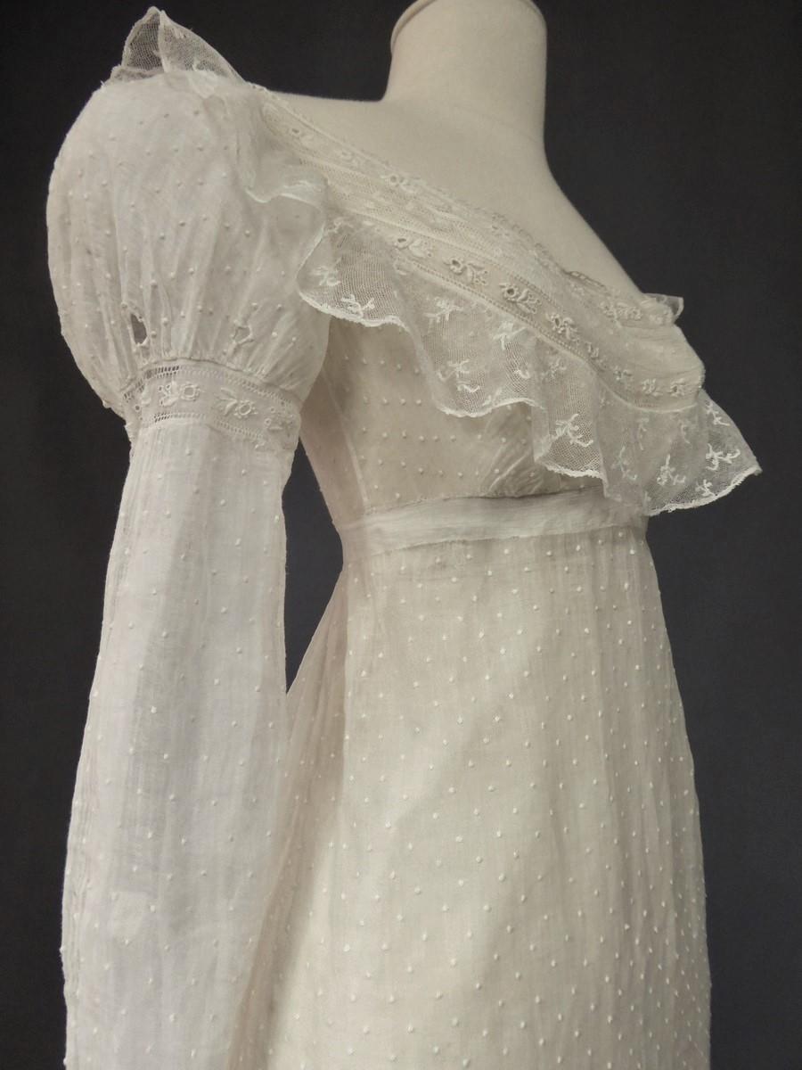 Circa 1810
France

Day dress in muslin and veil embroidered with plumetis, Mameluck sleeves , dating from the first French Empire. Large neckline in lace on a high-waisted fitted bodice. Small balloon sleeves with eyelets for tightening with a
