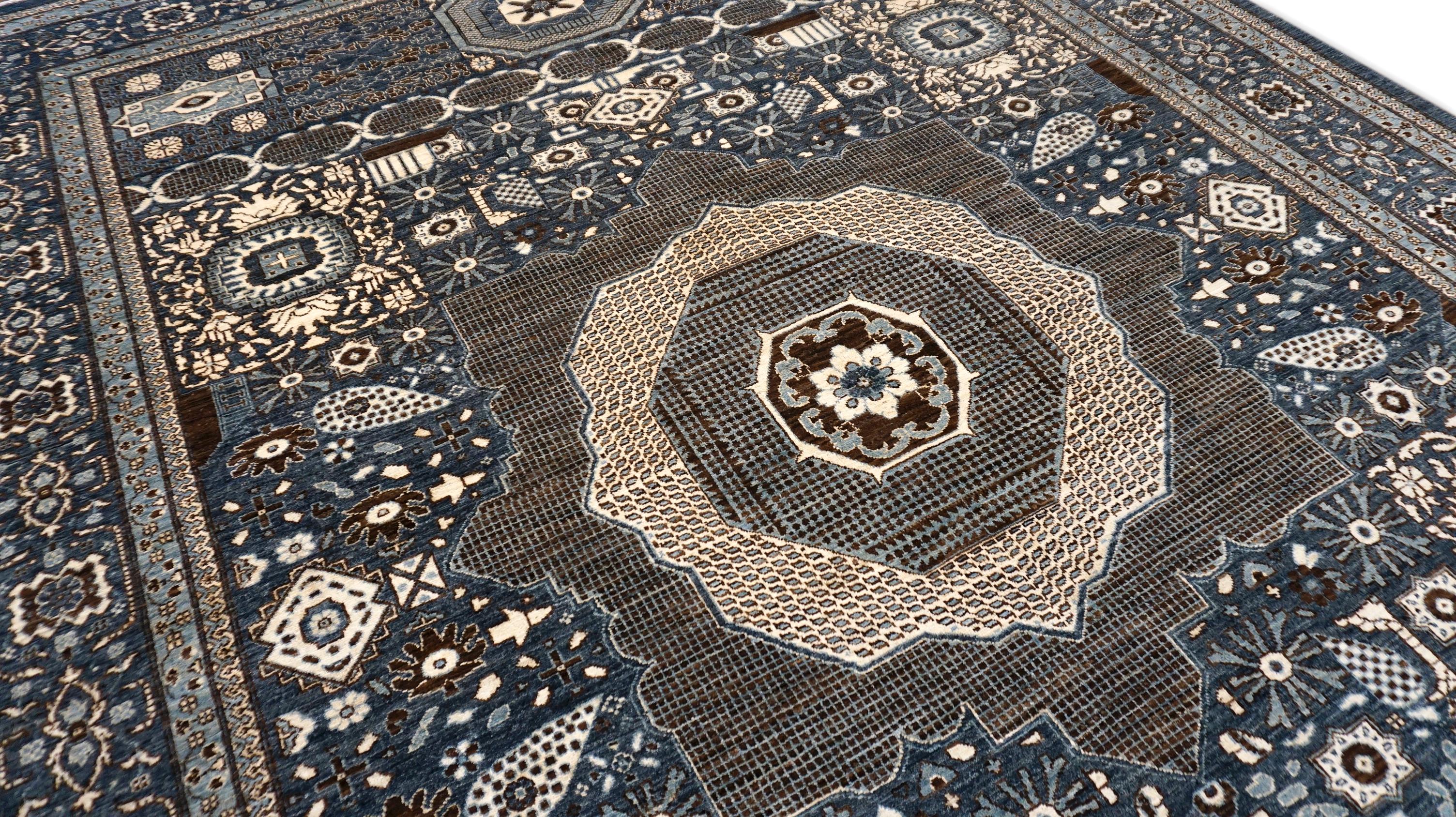 Questo squisito tappeto in lana annodato a mano è uno straordinario esempio di maestria artigianale infusa con una moderna precisione geometrica. Caratterizzato da una sofisticata tavolozza di blu intenso, avorio e marrone, il tappeto presenta un