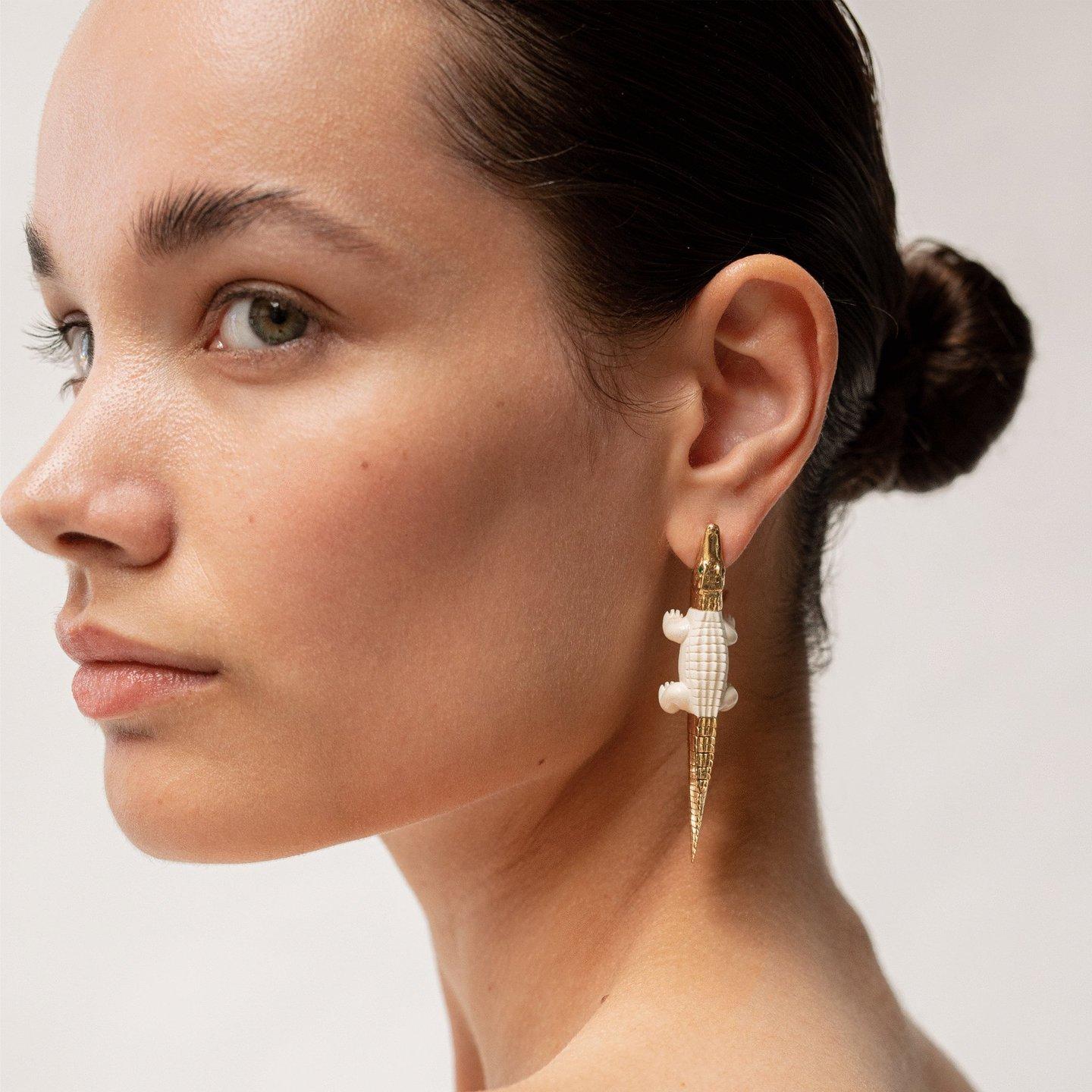 Intricately carved to replicate an alligator’s body in miniature, this earring conveys a fierce glamour. The earring is designed in 18k yellow gold and 60,000-year-old mammoth tusk, with the alligator’s mouth acting as the earring’s closing