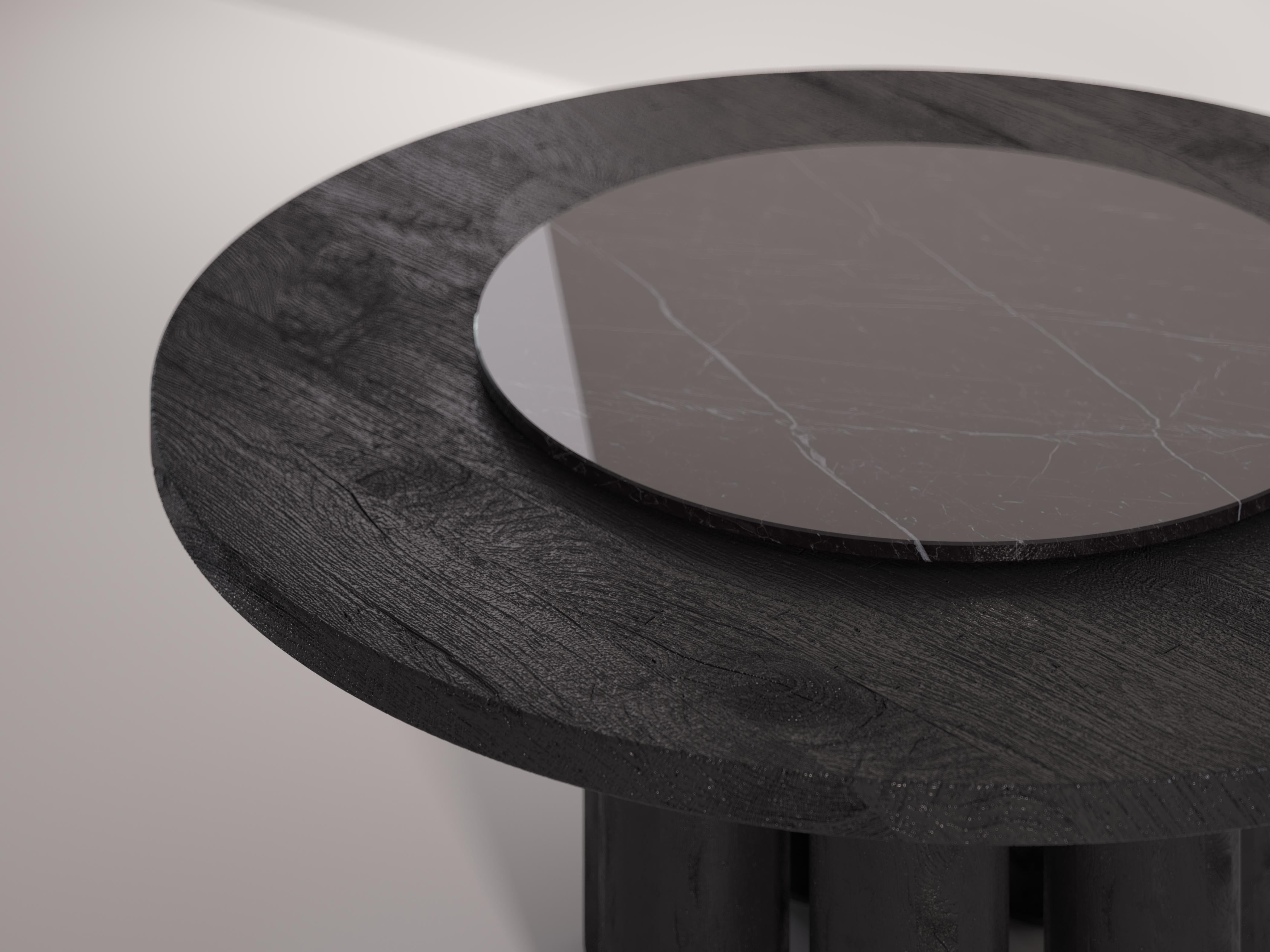 Mammoth is a luxurious circular dining table completely handmade in Italy with recovered solid wood. The piece once assembled is burned and finished by hand to make it durable over time. 
A lazy susan is incorporated within the top to allow maximum