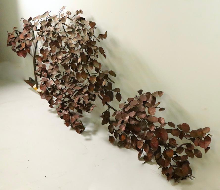 Fenomenale scultura brutalista a forma di albero mosso dal vento. La scultura ha un tronco e dei rami in ferro battuto con foglie in rame, è progettata per essere installata su una parete ed è adatta sia per l'interno che per l'esterno. Di