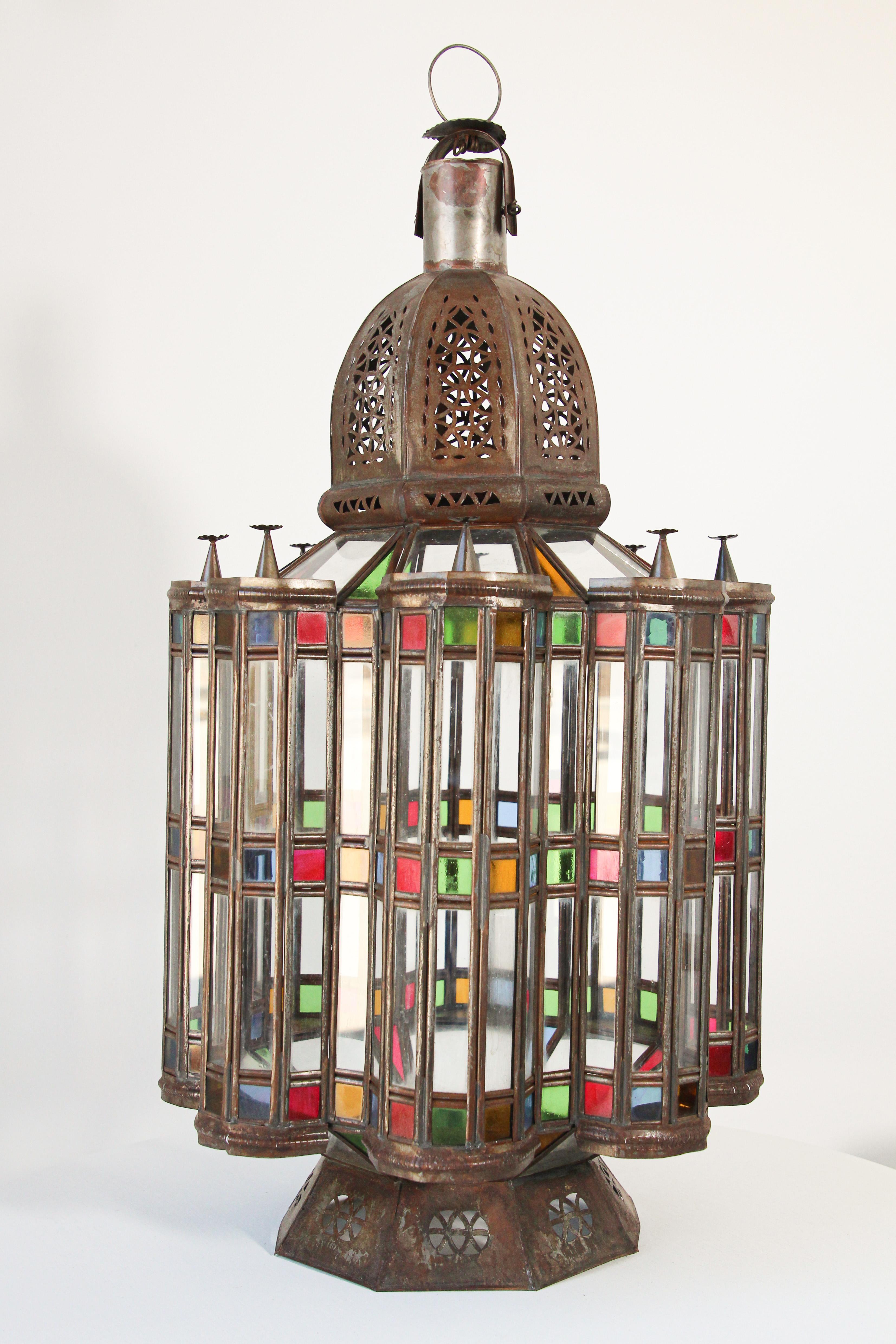 Large Moroccan Mamounia glass lantern with Moorish design.
Elegant Impressive intricate pierced metal and glass Moroccan lantern.
Large 29 inches tall with clear, blue, green, red and gold blown glass all around.
Very fine craftsmanship, antiqued