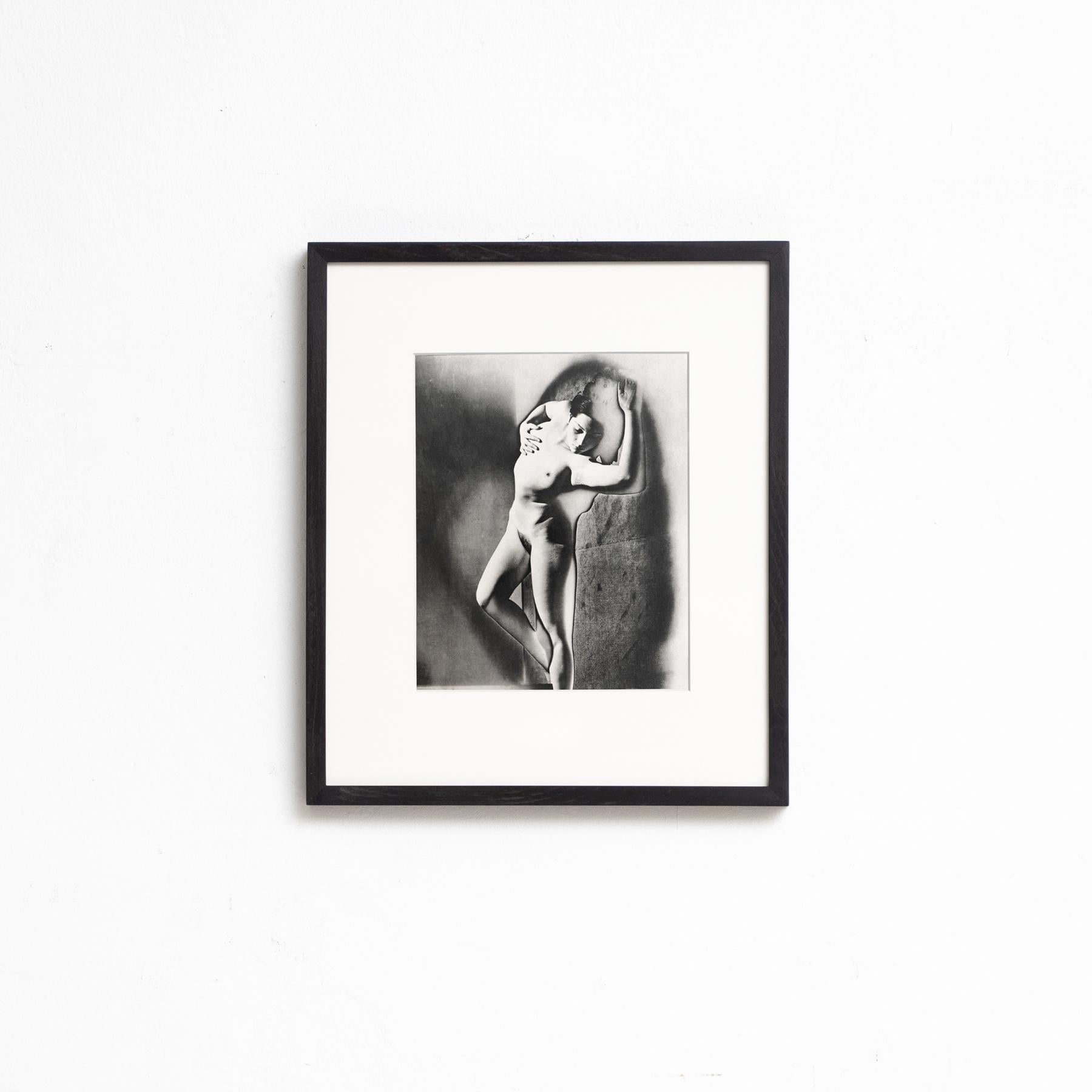 Tauchen Sie mit diesem gerahmten Schwarz-Weiß-Foto, einem Meisterwerk der surrealistischen Kunst, in die surrealistische Welt von Man Ray ein. Dieses im Heliogravurverfahren gedruckte Kunstwerk ist Teil einer auf 1000 Exemplare limitierten Auflage,