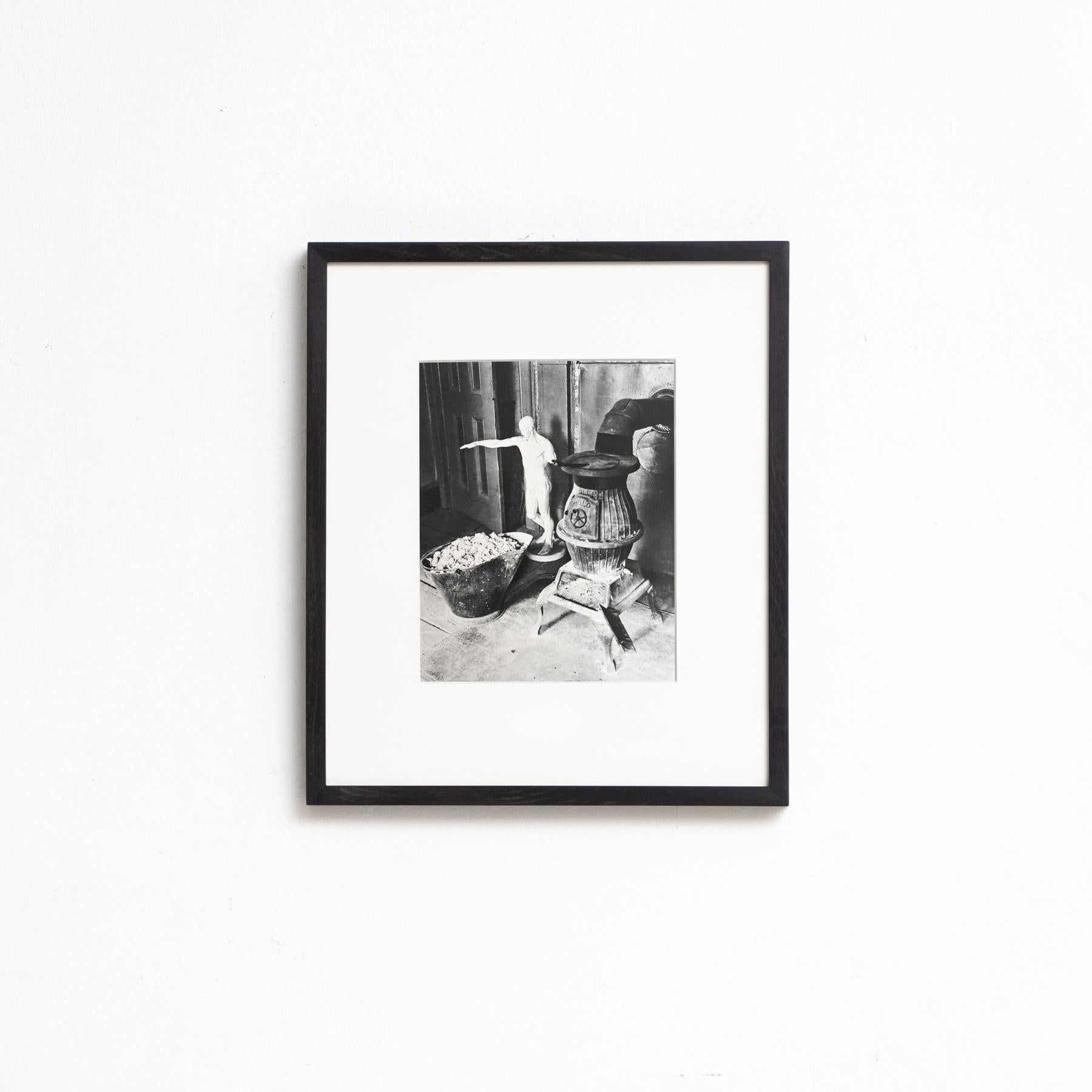 Tauchen Sie mit diesem gerahmten Schwarz-Weiß-Foto, einem Meisterwerk der surrealistischen Kunst, in die surrealistische Welt von Man Ray ein. Dieses im Heliogravurverfahren gedruckte Kunstwerk ist Teil einer auf 1000 Exemplare limitierten Auflage,