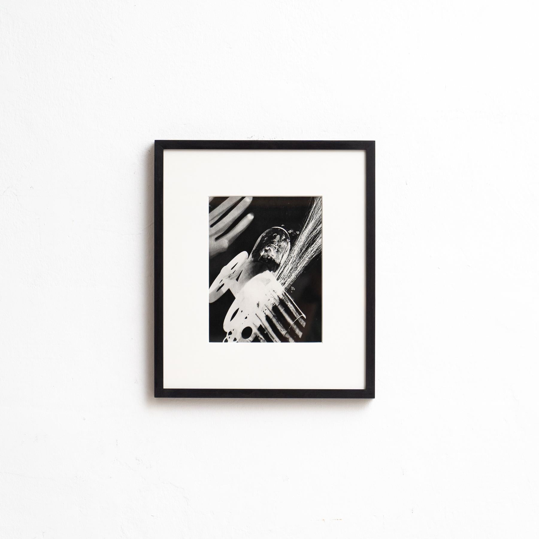 Descubre la elegancia atemporal de esta Rayografía en blanco y negro enmarcada del legendario artista y fotógrafo Man Ray. Esta obra única, impresa en heliograbado, forma parte de una edición limitada de 1000 ejemplares, publicada por el Gruppo