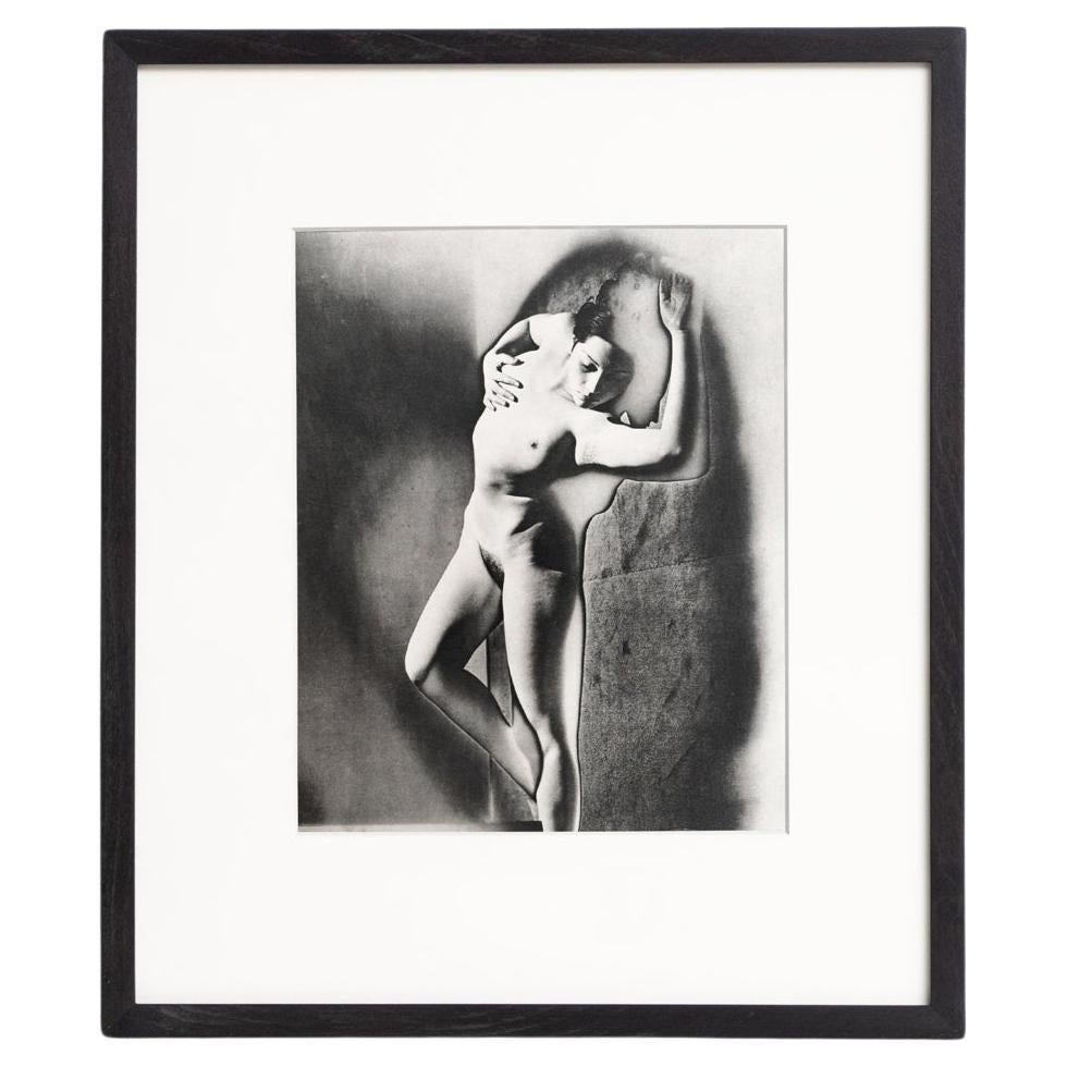 Tauchen Sie mit diesem gerahmten Schwarz-Weiß-Foto, einem Meisterwerk der surrealistischen Kunst, in die surrealistische Welt von Man Ray ein. Dieses im Heliogravurverfahren gedruckte Kunstwerk ist Teil einer auf 1000 Exemplare limitierten Auflage,