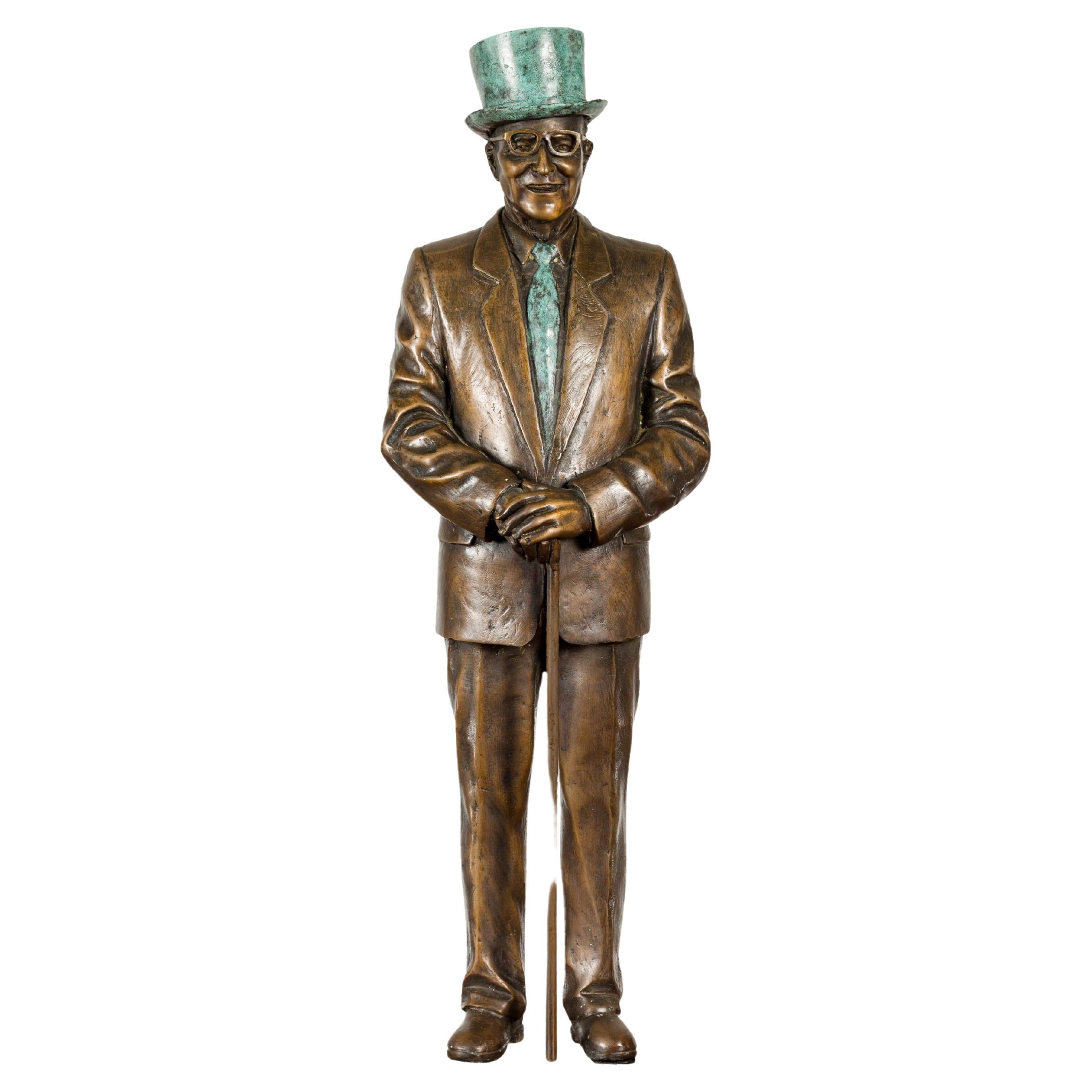 A bronze tabletop statuette depicting a Man with Top Hat. Behold a captivating bronze tabletop statuette portraying a dapper Man with a Top Hat, a testament to meticulous craftsmanship. The statuette's allure lies in its exquisite details, from the