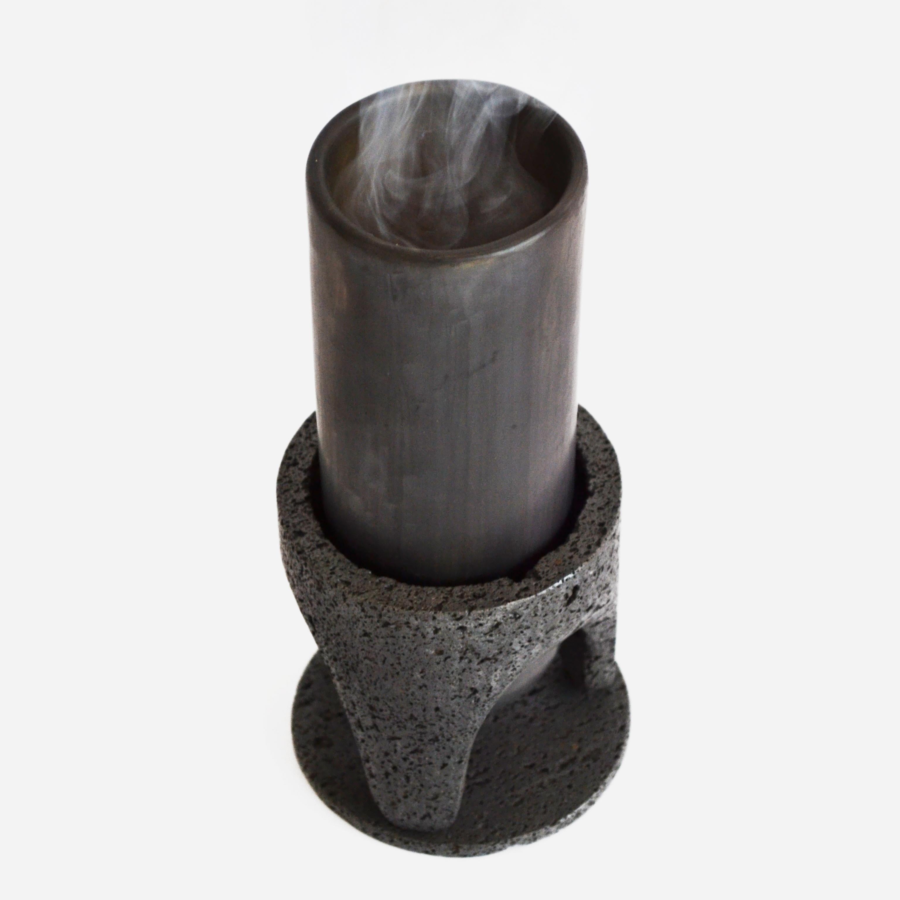 Manantial-Vase von Omar Ortiz, 2021
Abmessungen: H21 x B10cm
MATERIALIEN: Vulkanisches Gestein, schwarzer Ton.

Ist eine Vase, die durch einen handgeschnitzten Steinsockel vom Boden abgehoben wird. Die Vase hält Feuer unter 950 Grad stand, so dass