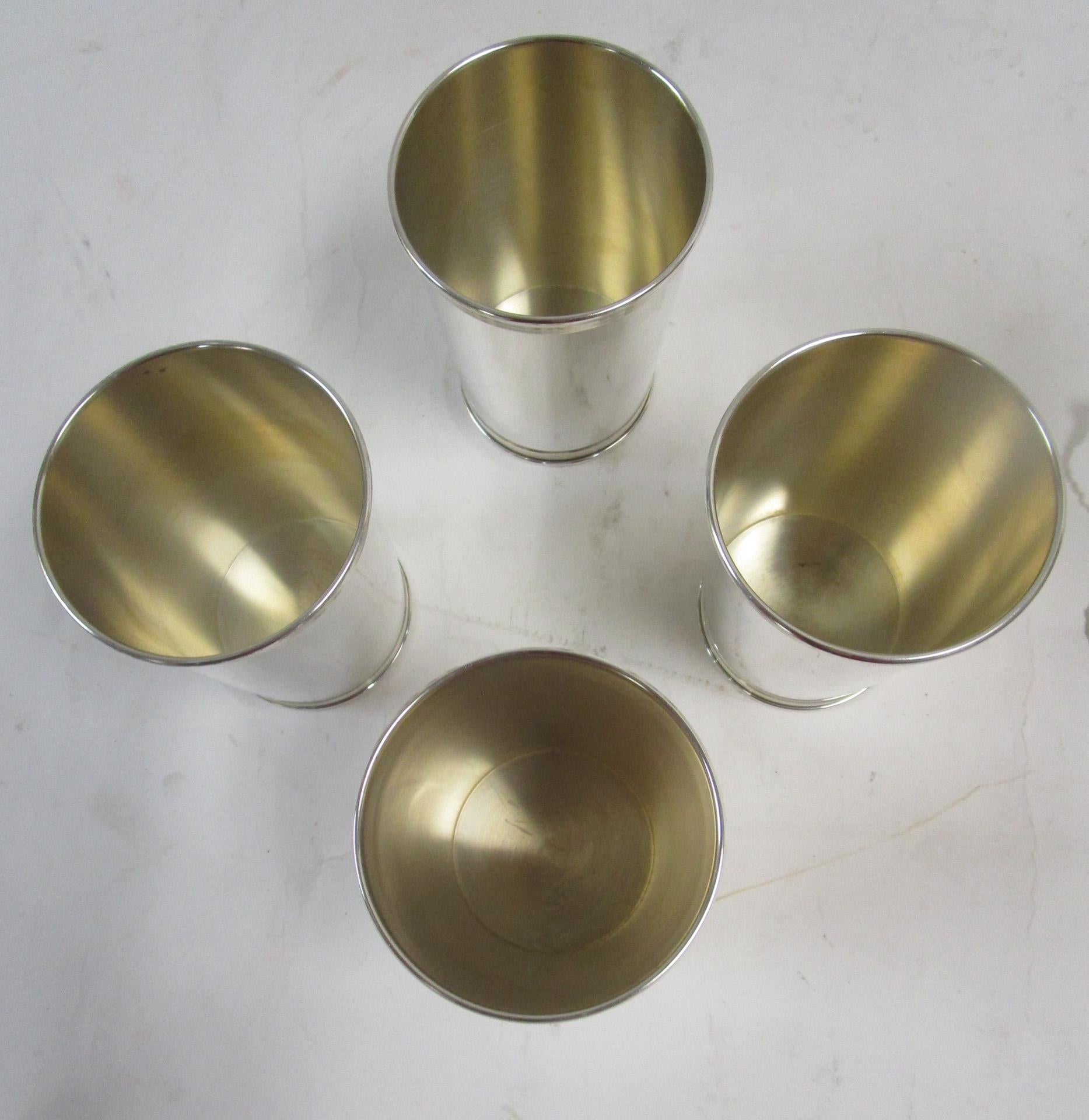Made in the mid-20th century, this set of four sterling silver mint julep cups are a timeless classic that would make any Kentucky Derby Party an event to remember.
 The rims and bases are decorated with reeded detail, the interiors show traces of