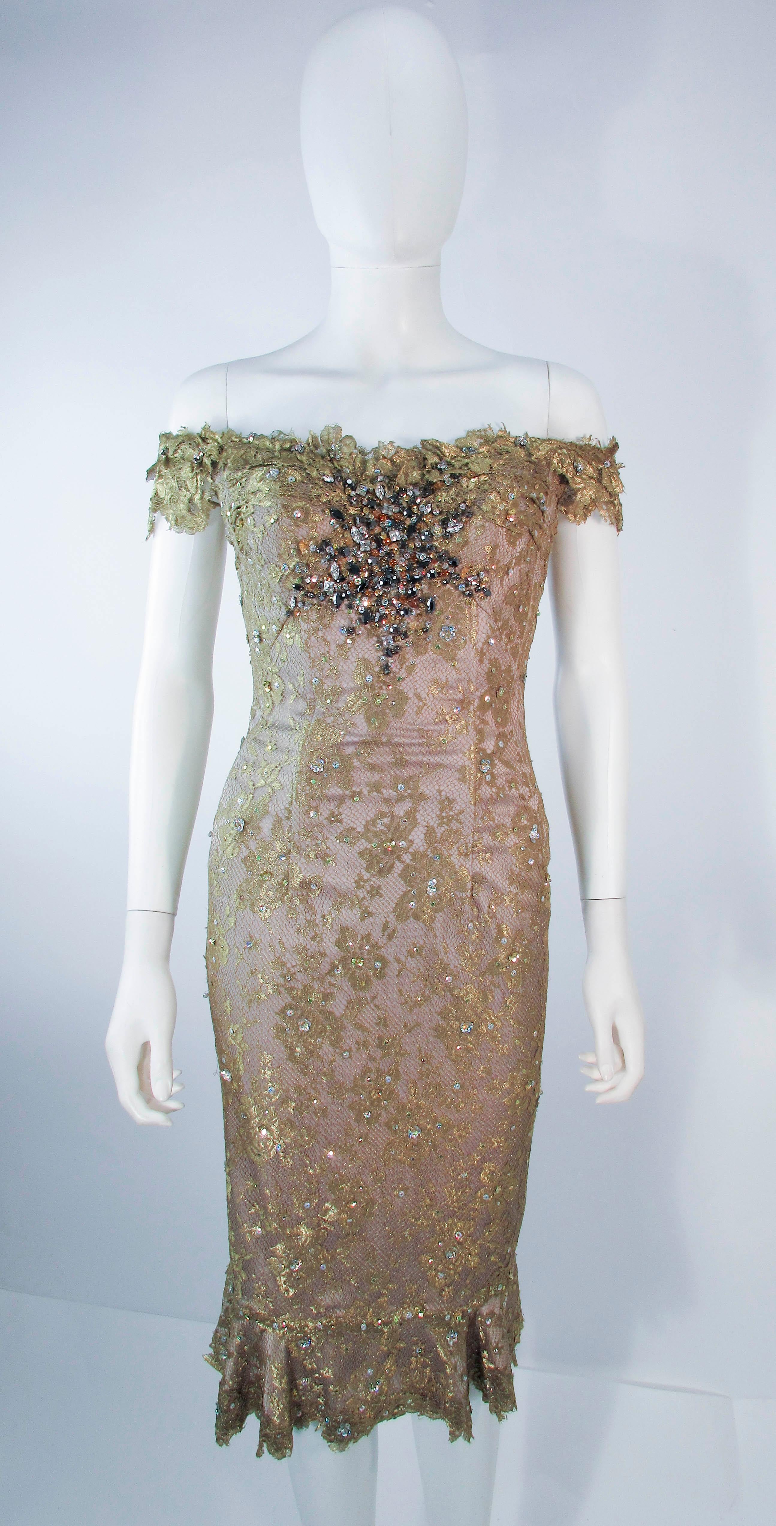 Este es un vestido de cóctel Madalay, está compuesto por un dorado metalizado con un aplique de cuentas y lentejuelas. Presenta un estilo sin hombros con corsé y cierre de cremallera central en la espalda. En excelente estado de segunda mano,