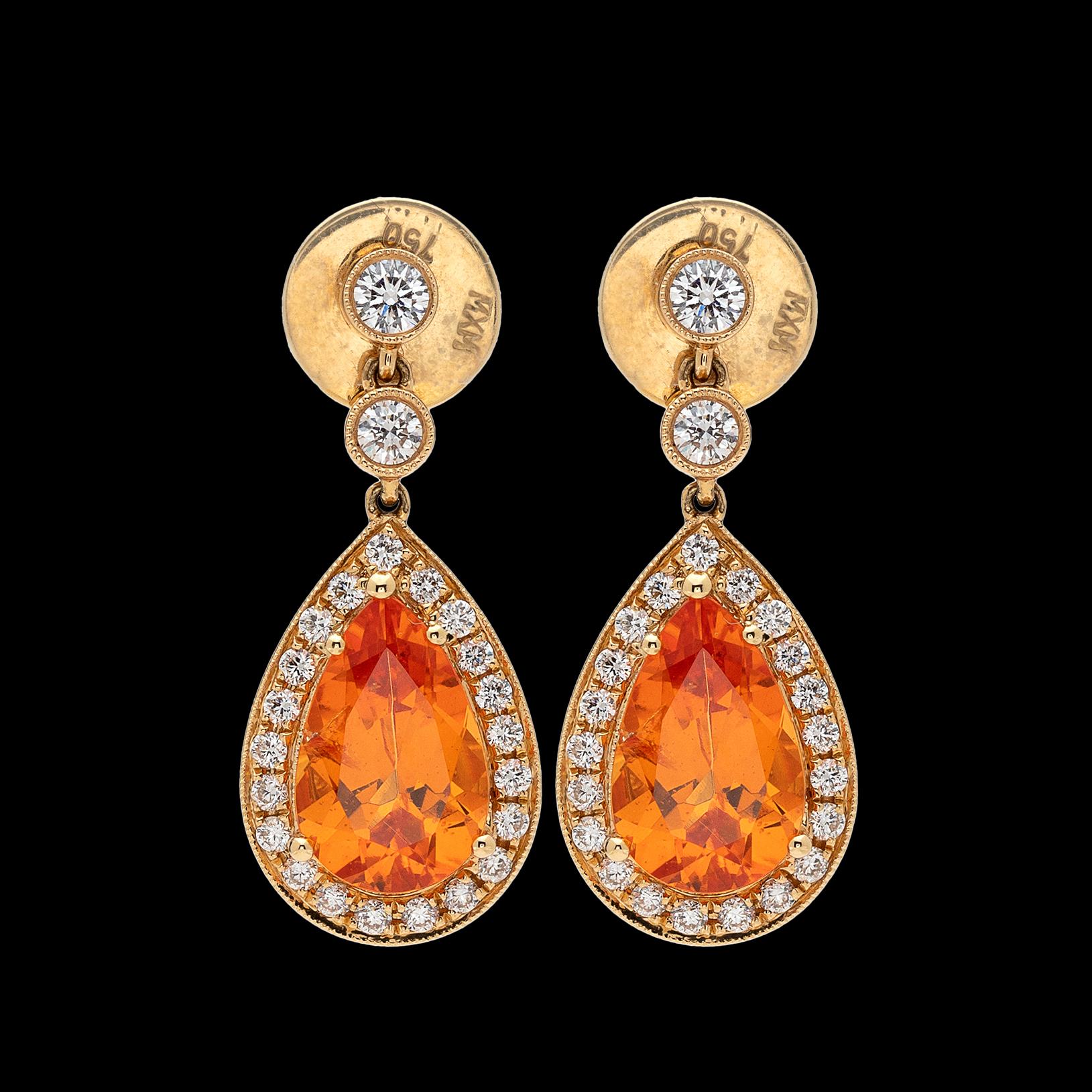 Set in 18k yellow gold, the drop earrings feature two beautiful yellowish orange pear-shaped Mandarin garnets, weighing together an estimated 5.16 carats, each framed and topped by round brilliant-cut diamonds, weighing in total approximately
