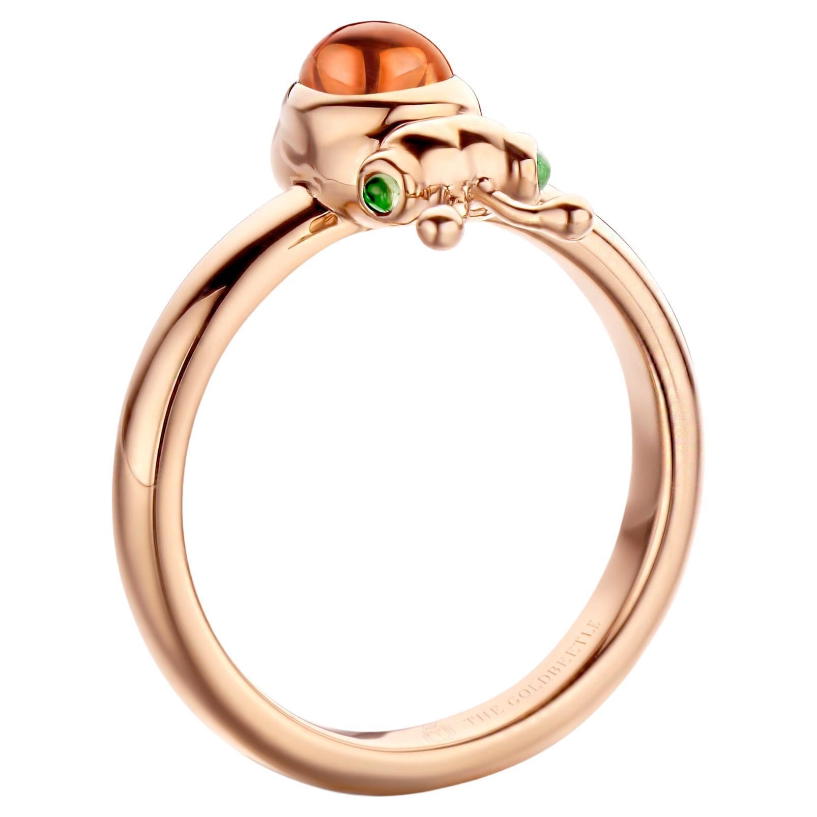 Lilou-Ring aus 18 Karat Roségold, besetzt mit einem natürlichen birnenförmigen Mandarin-Granat im Cabochon-Schliff und zwei natürlichen Tsavoriten im runden Cabochon-Schliff.

Celine Roelens, Goldschmiedin und Gemmologin, hat sich auf einzigartigen,
