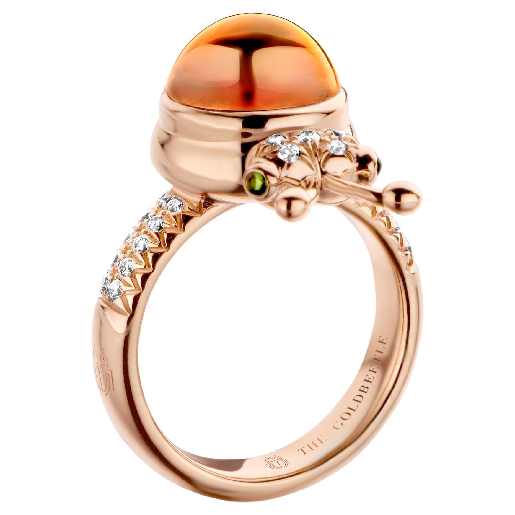 One-of-a-kind lucky beetle ring in 18 Karat rose gold 10g set with the finest natural diamonds in brilliant cut 0,23 Carat (VVS/DEF quality) one natural, mandarin garnet in round cabochon cut 6,00 Carat and two tsavorites in round cabochon cut.