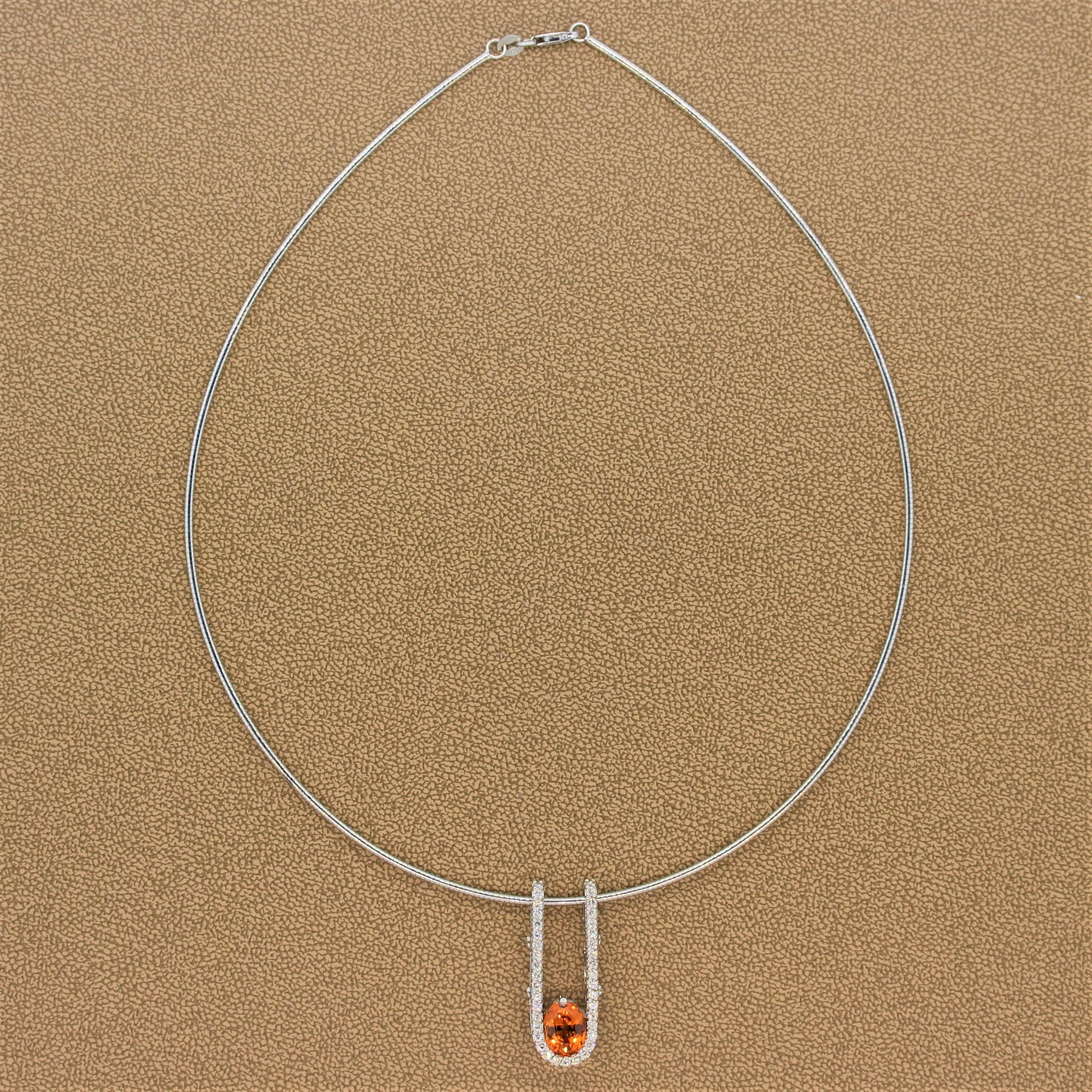 A modern slide pendant featuring a gem 2.77 carat mandarin garnet. The oval shaped gemstone has a vivid orange color with amazing life and brilliance. It sits at the bottom of a 14K white gold setting being cradled by 0.71 carats of colorless round