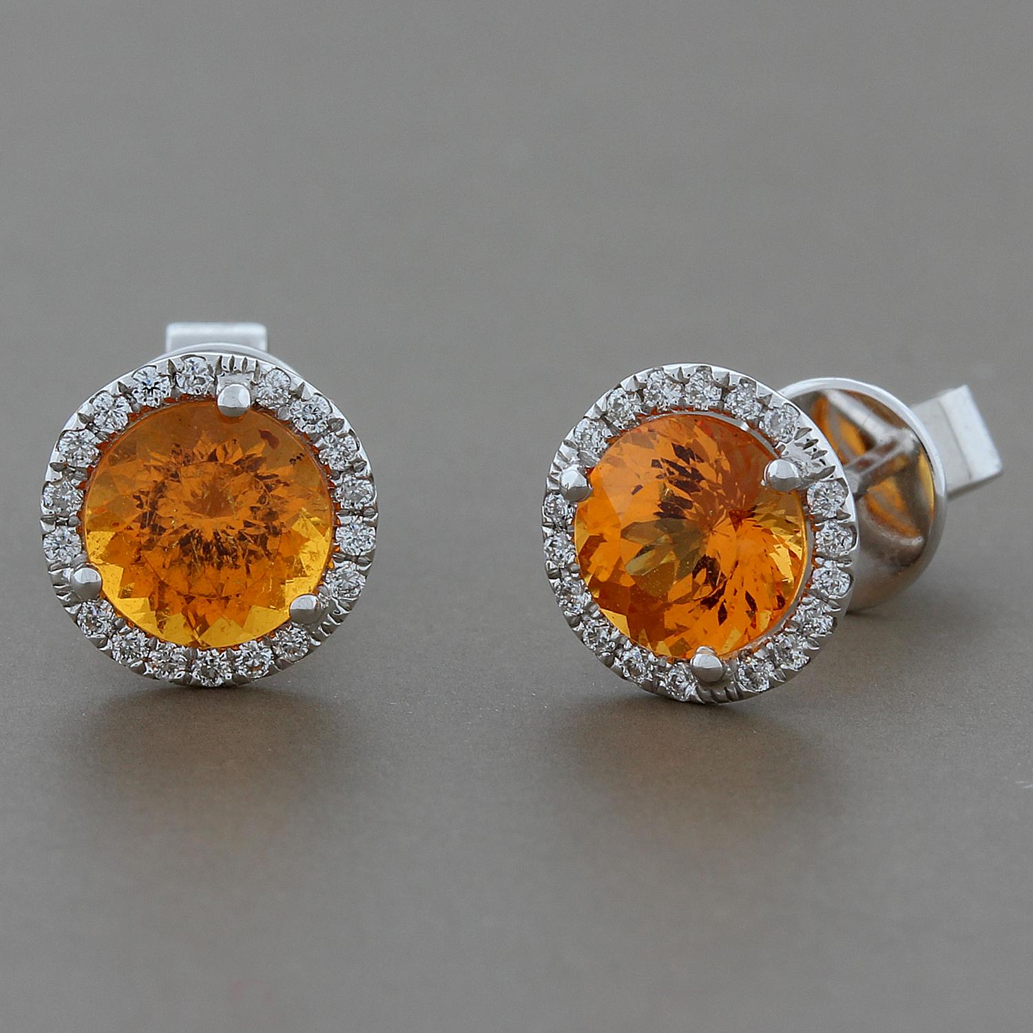 The perfect everyday stud earrings with a pop of orange!  Featuring 2.12 carats of round mandarin garnet, in a classic halo of 0.16 carats of VS quality round white diamonds. Set in 18K white gold.

Approximately, 8 mm diameter
