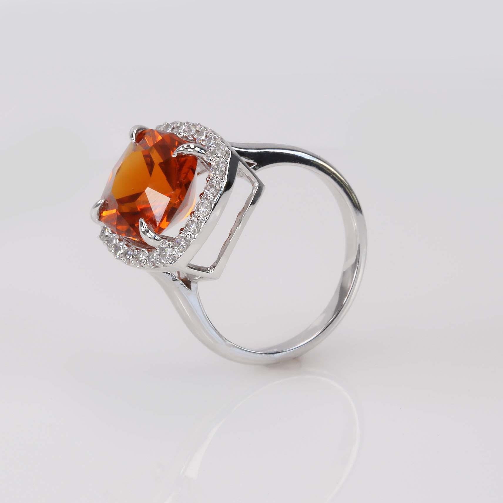 Mandarin Garnet & Diamond Halo Ring

Creator: Carson Gray Jewels	
Ring Size: 6.5
Metal: 18KT White Gold
Stone: Mandarin Garnet and Diamonds
Stone Cut: Radiant Brilliant
Weight: Garnet 6.95 carats; 0.46 carats of diamonds
Style: Statement Ring
Place