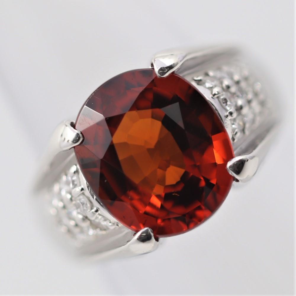 Une belle bague en platine ornée d'un beau grenat spessartine d'une riche couleur orange royal lui conférant le nom de mandarine. Il pèse 6,92 carats et présente une clarté exceptionnelle pour un grenat mandarin, ce qui permet aux pierres d'avoir