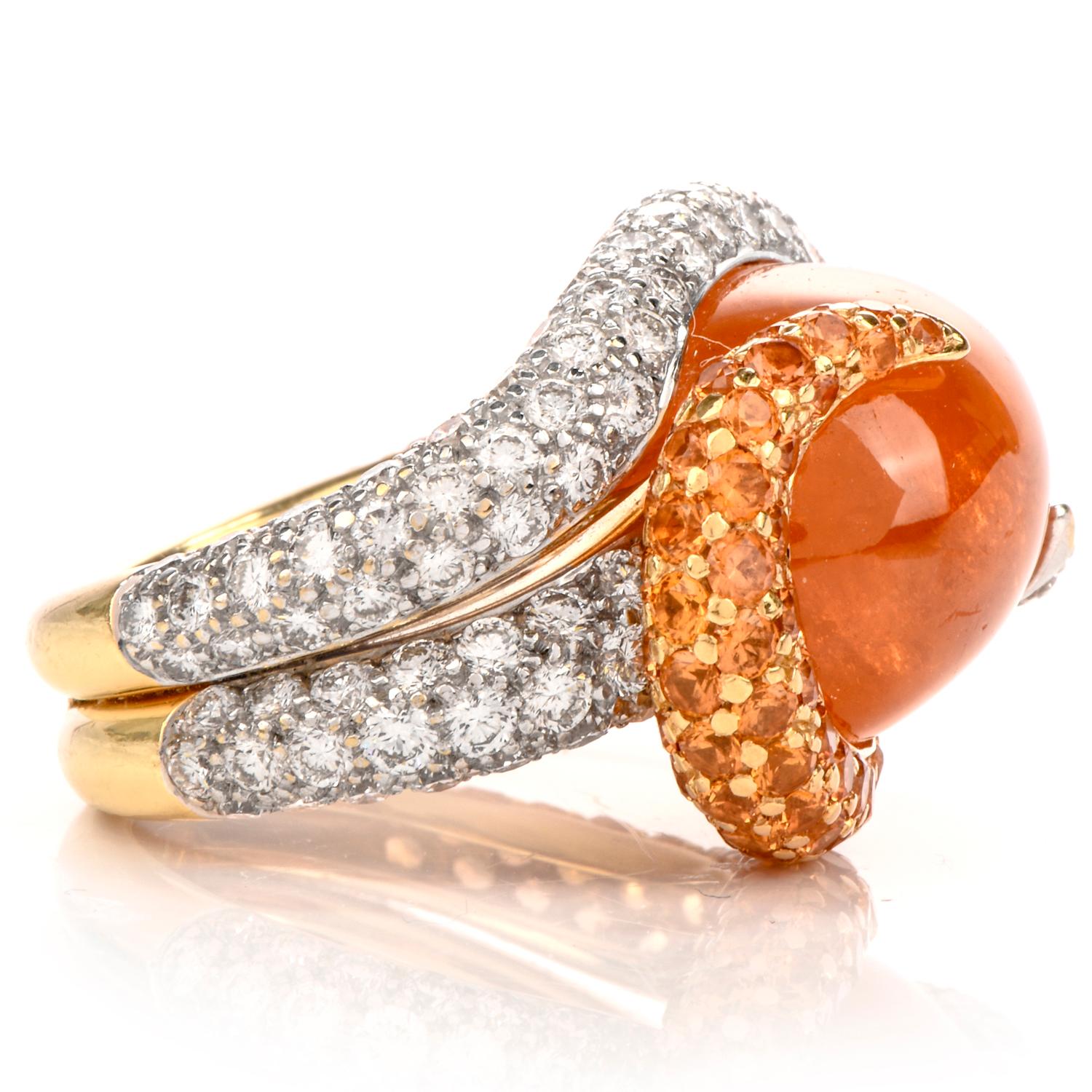 This unique well made garnet and diamond cocktail ring is crafted in 18-karat yellow gold, weighing 20.3 grams and measuring 19mm x 11mm high. Exposing a prominent bezel set, oval cabochon, mandarine garnet wighing approx 20.05 carats. Entwined by a