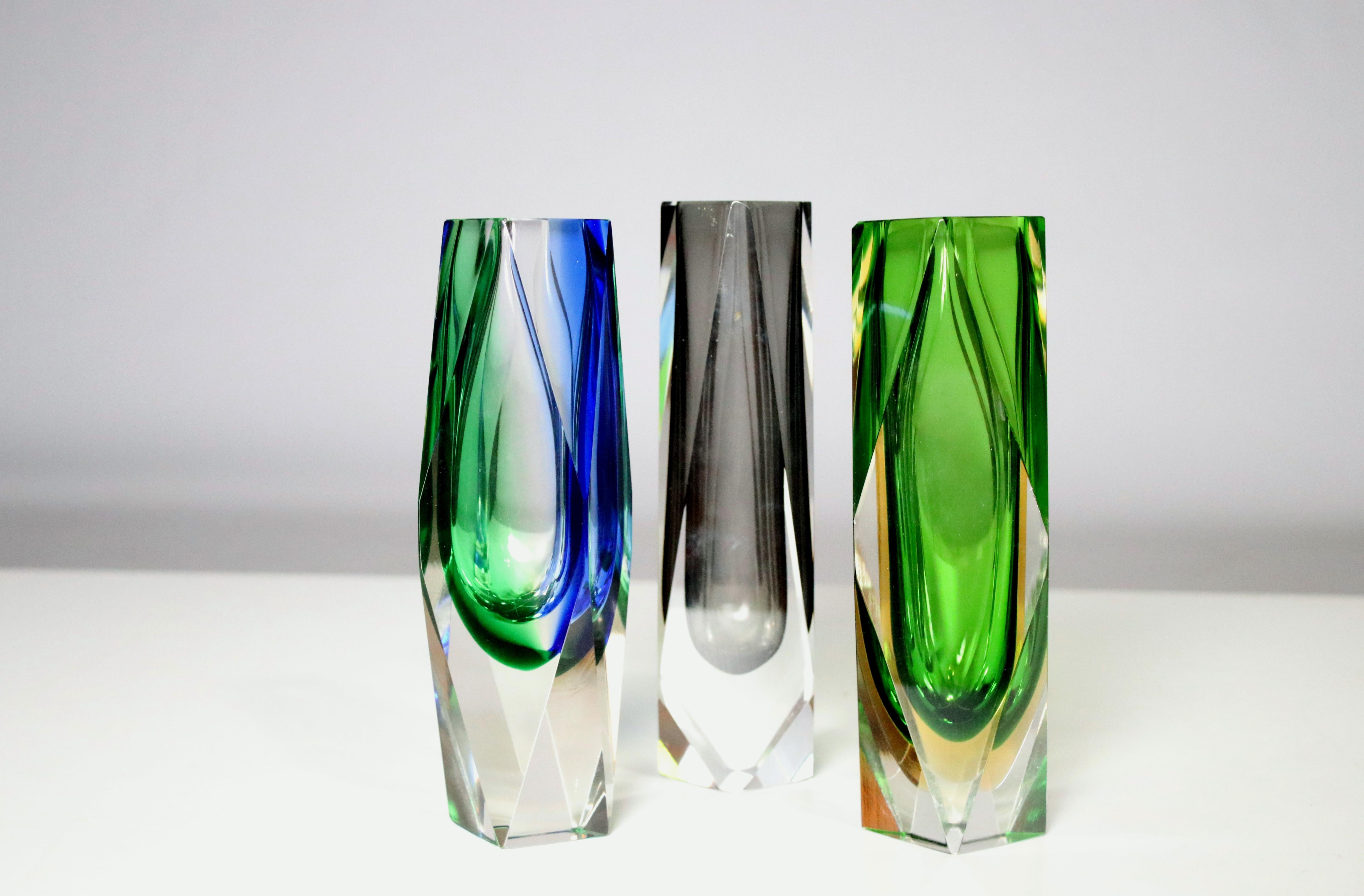 A collection of 3 Mandruzzato Murano faceted art glass vases one in smoke, one in green and one in blue/green. All the same shape and size. Excellent Vintage Condition, Original Condition Unaltered, No Imperfections.
