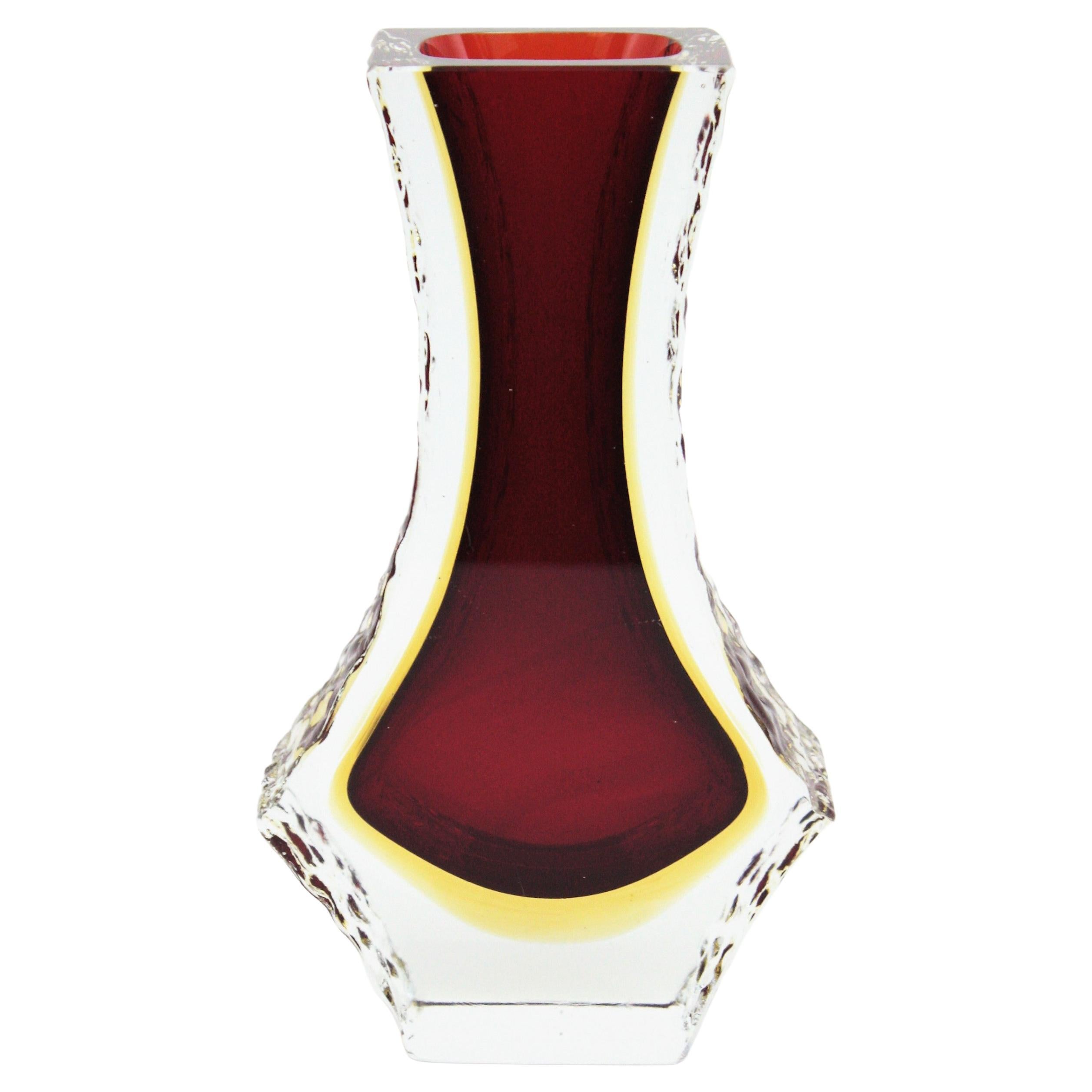 Vase en verre d'art de Murano à facettes du milieu du siècle, avec côtés en verre glacé texturé. Attribué à Mandruzzato, Italie, années 1960.
Technique Sommerso avec du verre rouge avec une couche en jaune immergée dans du verre clair.
Couleurs